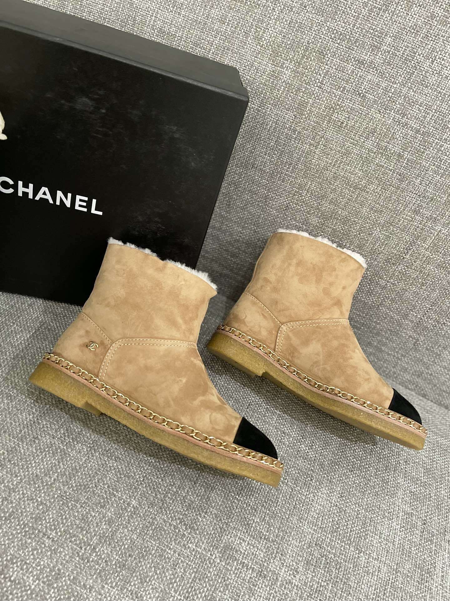 Pair of Chanel tan suede ankle boots with white shearling lining, black cap-toe, and gold chain sole detail. - Hình 9