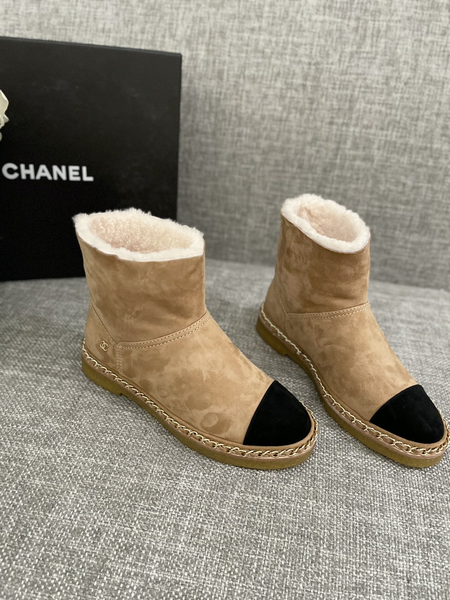 Pair of Chanel tan suede ankle boots with white shearling lining, black cap-toe, and gold chain sole detail. - Hình 2