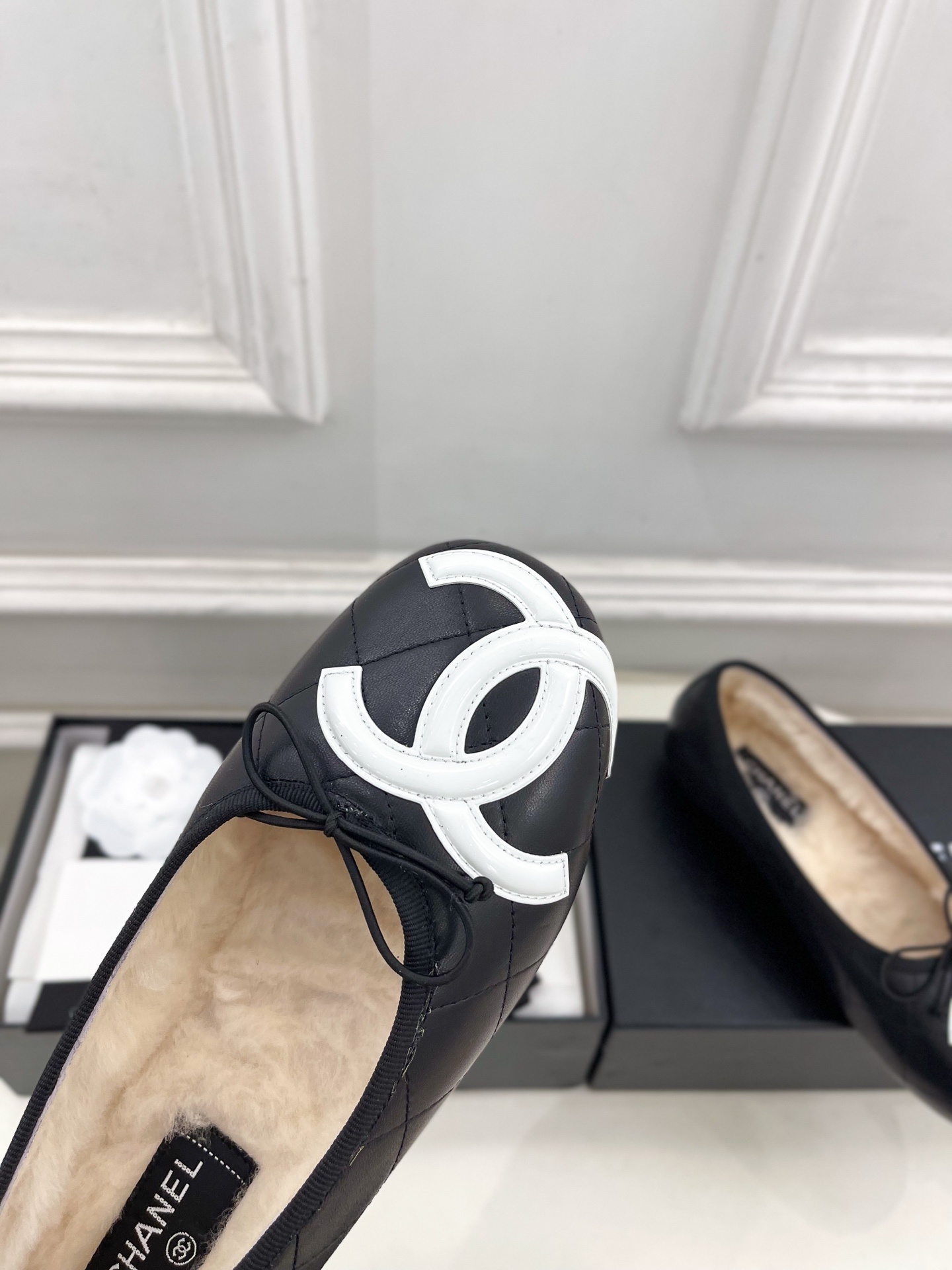 Black Chanel quilted leather ballerina flats with white CC logo and fur lining shown with luxury packaging - Hình 6
