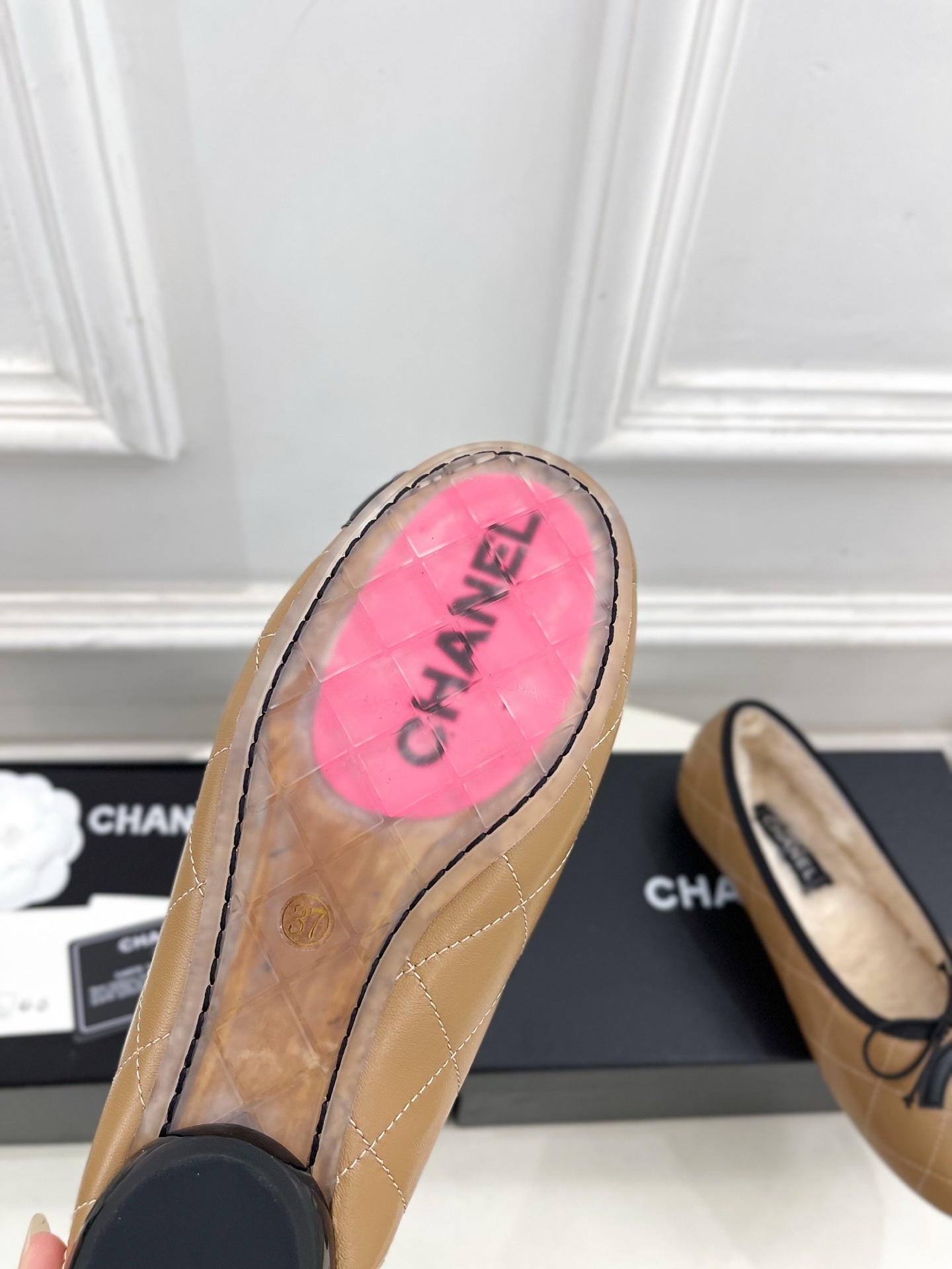 Pair of tan Chanel quilted ballerina flats with black CC logo and fuzzy shearling lining on a white table. - Hình 9