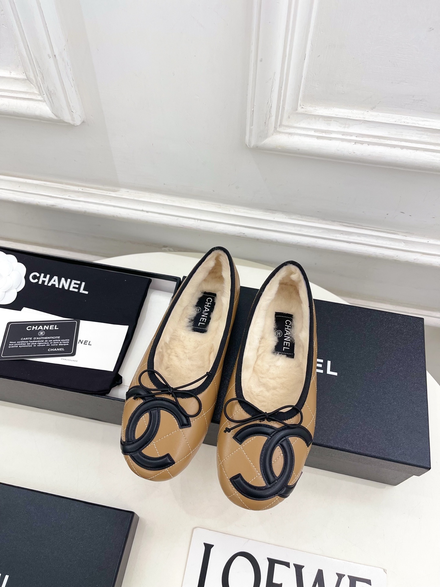 Pair of tan Chanel quilted ballerina flats with black CC logo and fuzzy shearling lining on a white table. - Hình 5