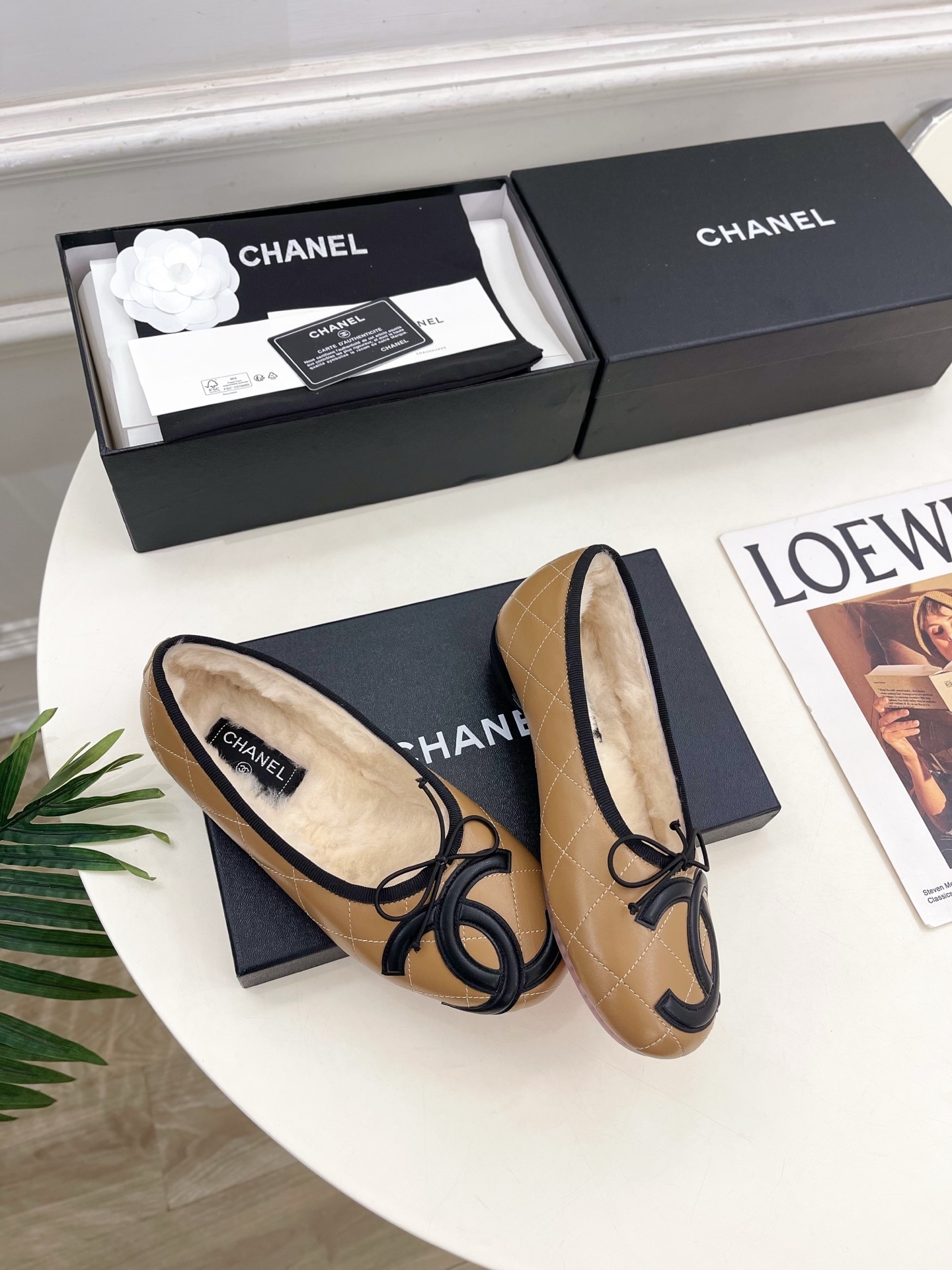 Pair of tan Chanel quilted ballerina flats with black CC logo and fuzzy shearling lining on a white table. - Hình 4