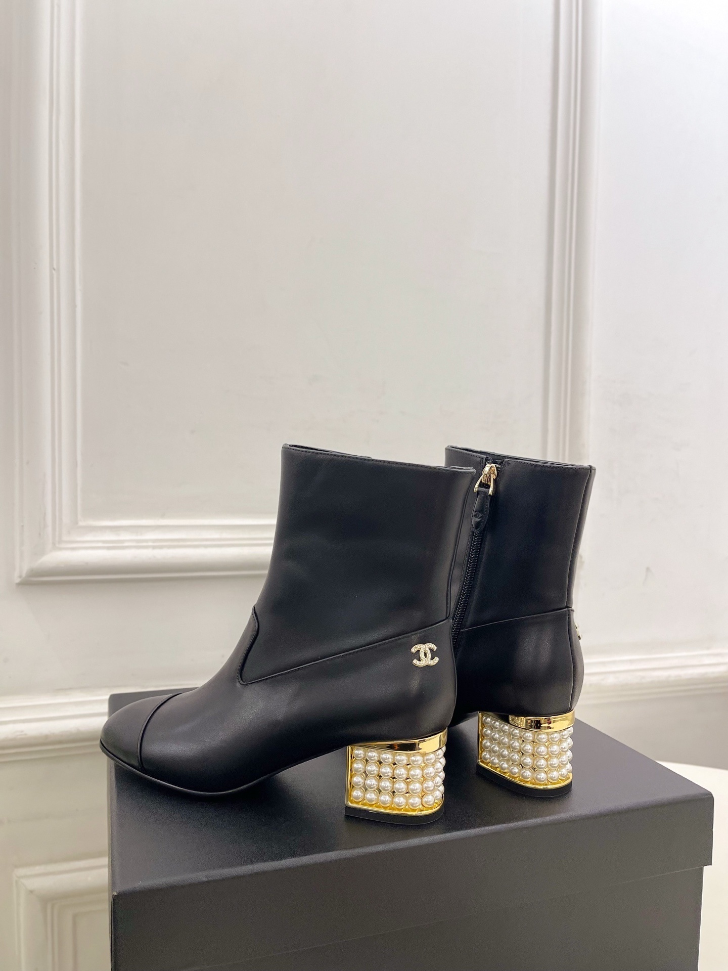 Elegant black leather ankle boots featuring a unique gold block heel decorated with rows of white pearls. - Hình 8
