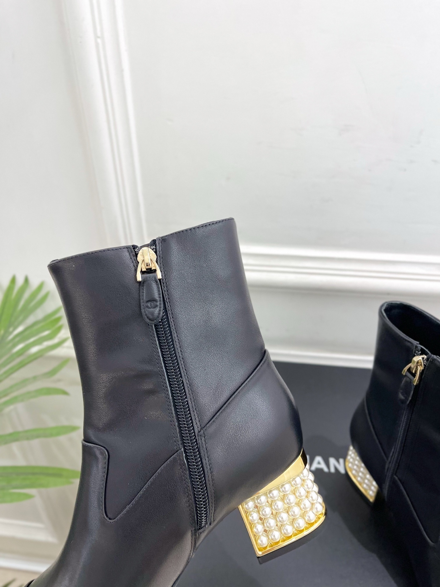 Elegant black leather ankle boots featuring a unique gold block heel decorated with rows of white pearls. - Hình 7