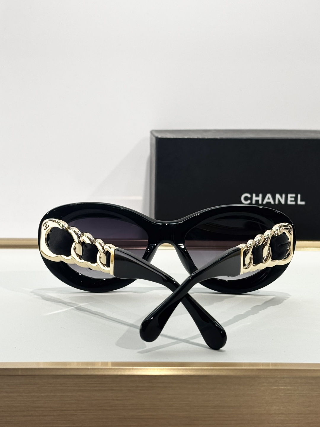 Chanel Luxury Oval Sunglasses - Black Frame with Gold Chain Detail
