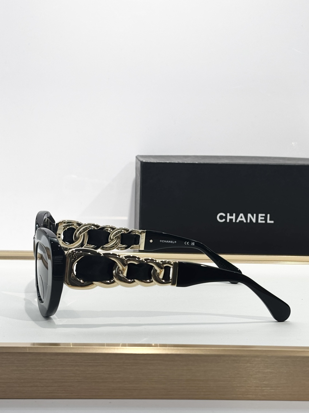 Chanel Luxury Oval Sunglasses - Black Frame with Gold Chain Detail