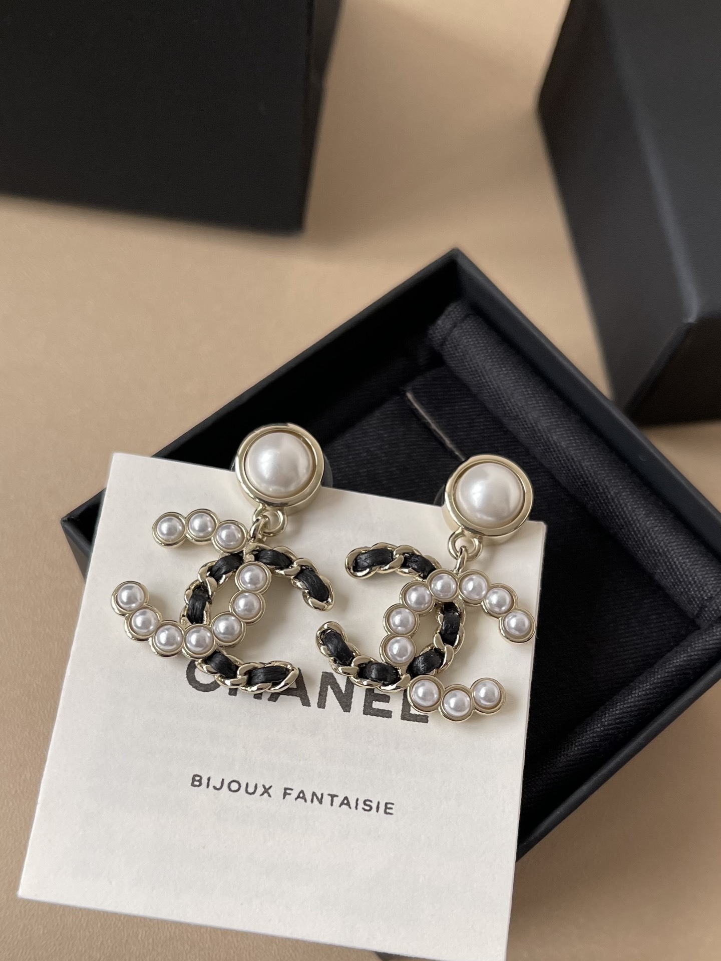 Elegant CC Logo Pearl Drop Earrings with Interwoven Black Leather