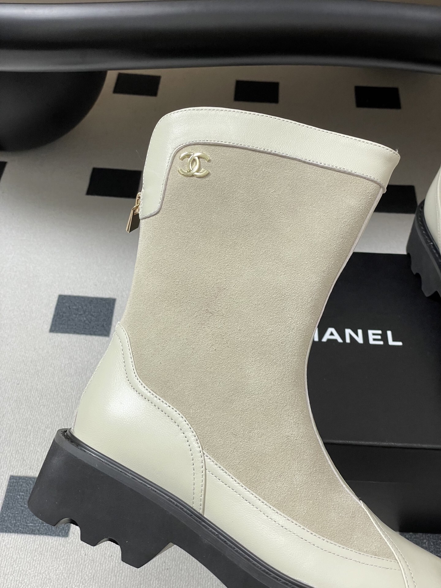 A pair of luxury Chanel off-white leather and suede mid-calf boots with thick black lug soles and gold CC logo detail. - Hình 8