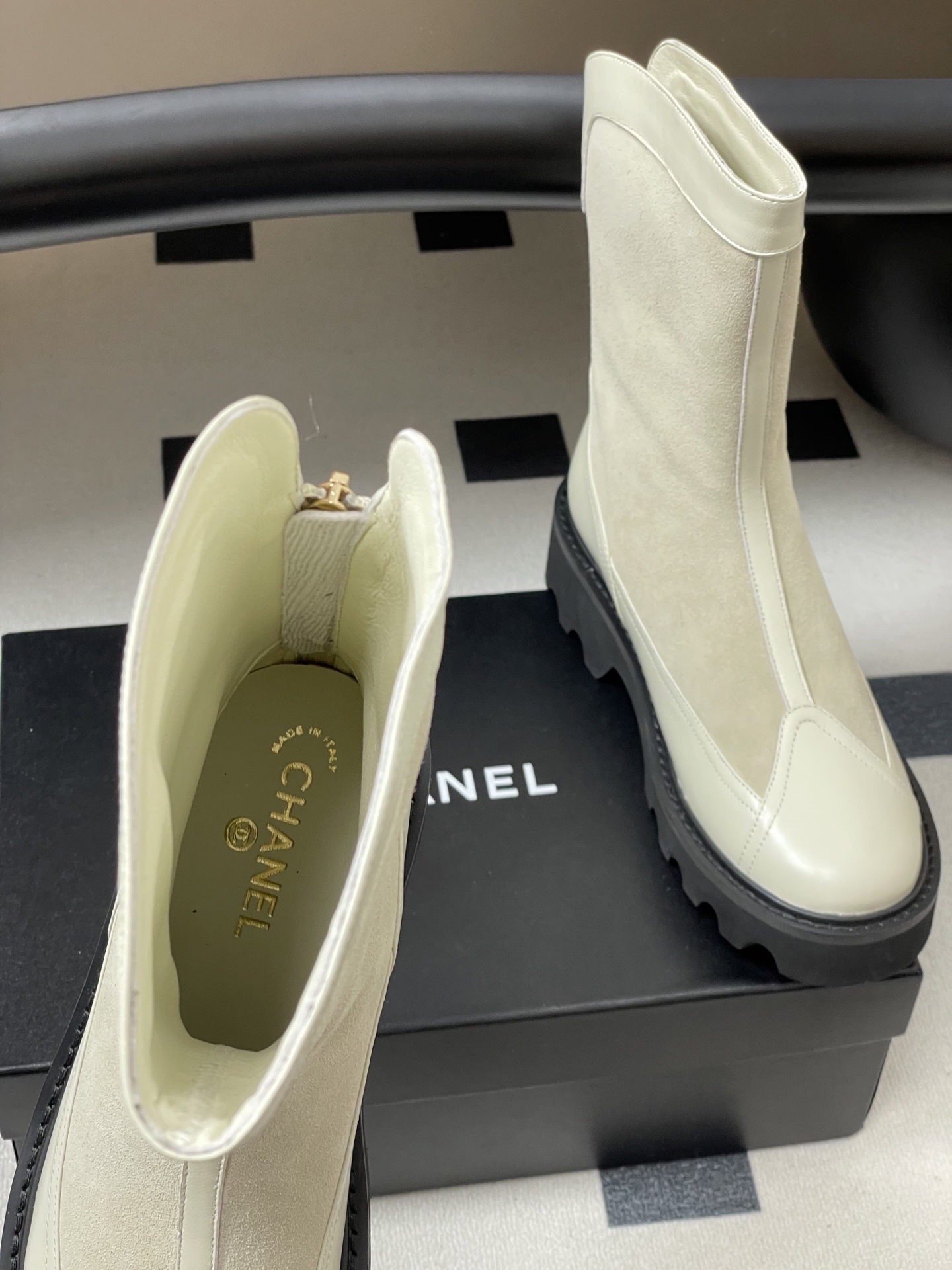 A pair of luxury Chanel off-white leather and suede mid-calf boots with thick black lug soles and gold CC logo detail. - Hình 6