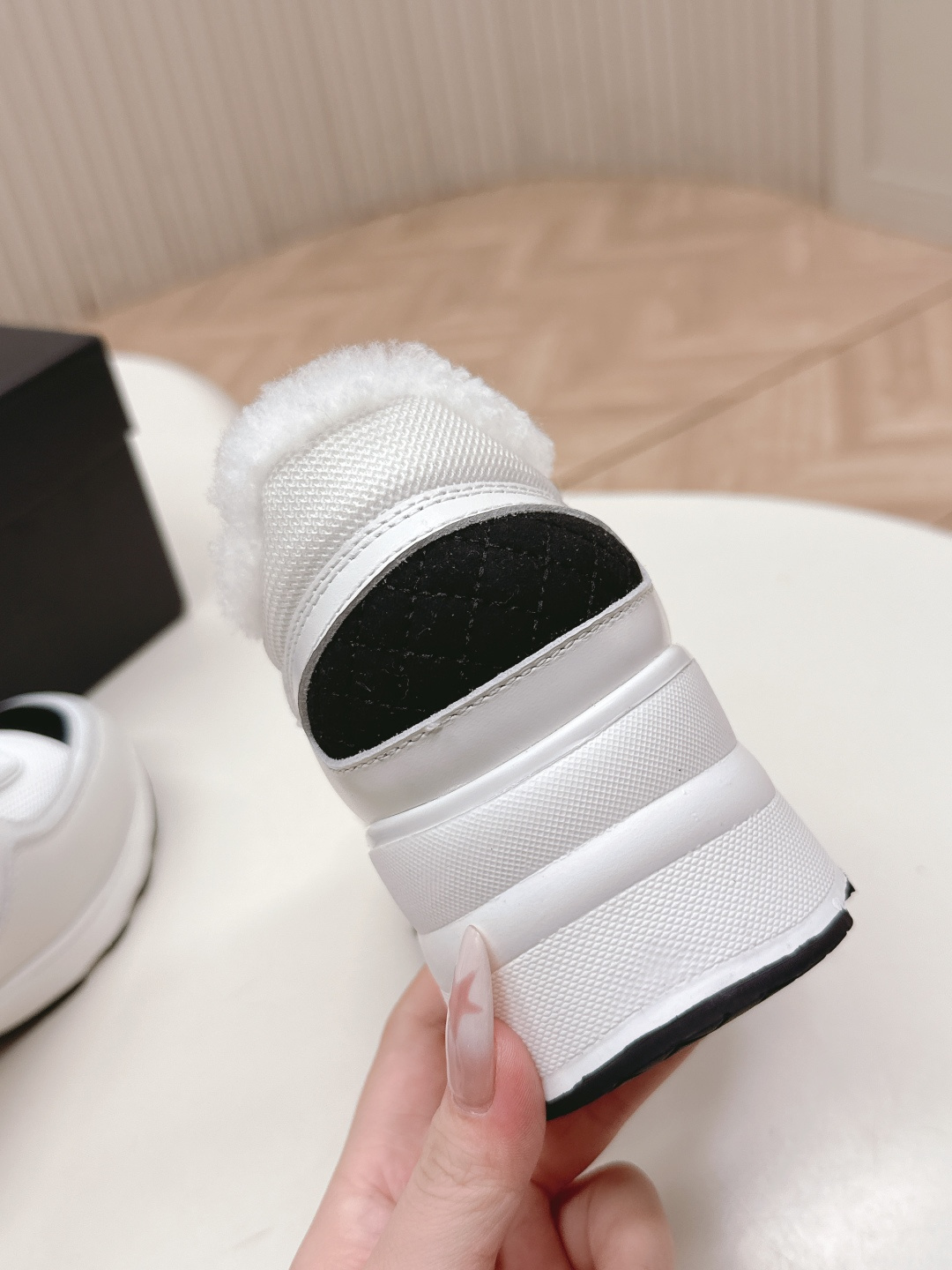A pair of luxury Chanel white platform sneakers with plush fur lining and black toe caps displayed on a white surface. - Hình 6