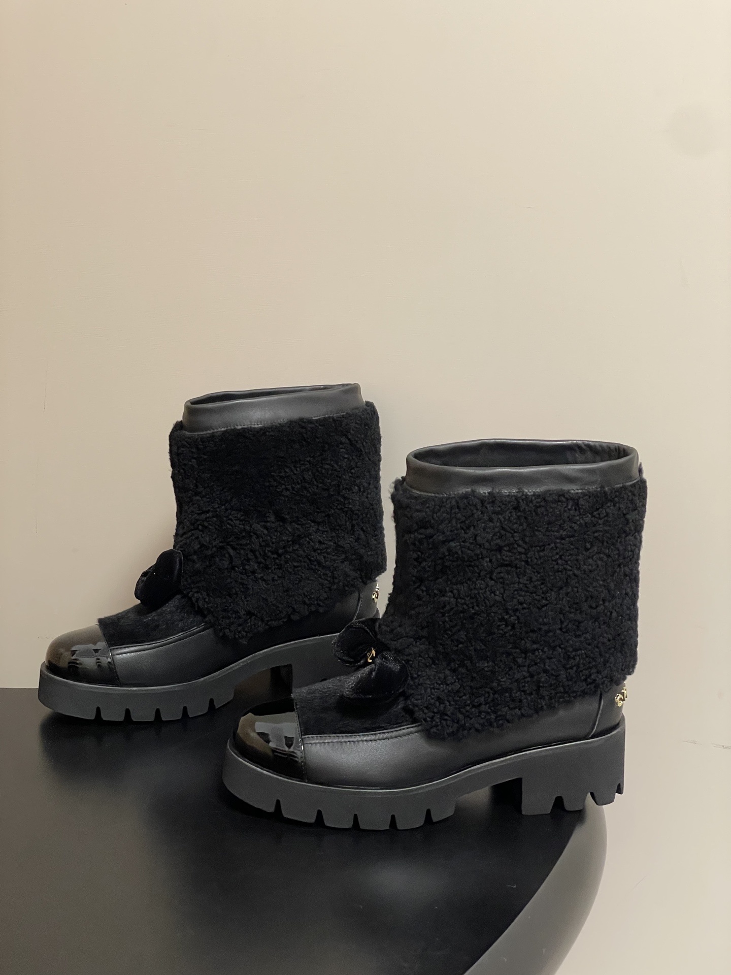 Pair of black luxury ankle boots with faux fur shearling shaft, velvet bow, and chunky lug soles - Hình 3