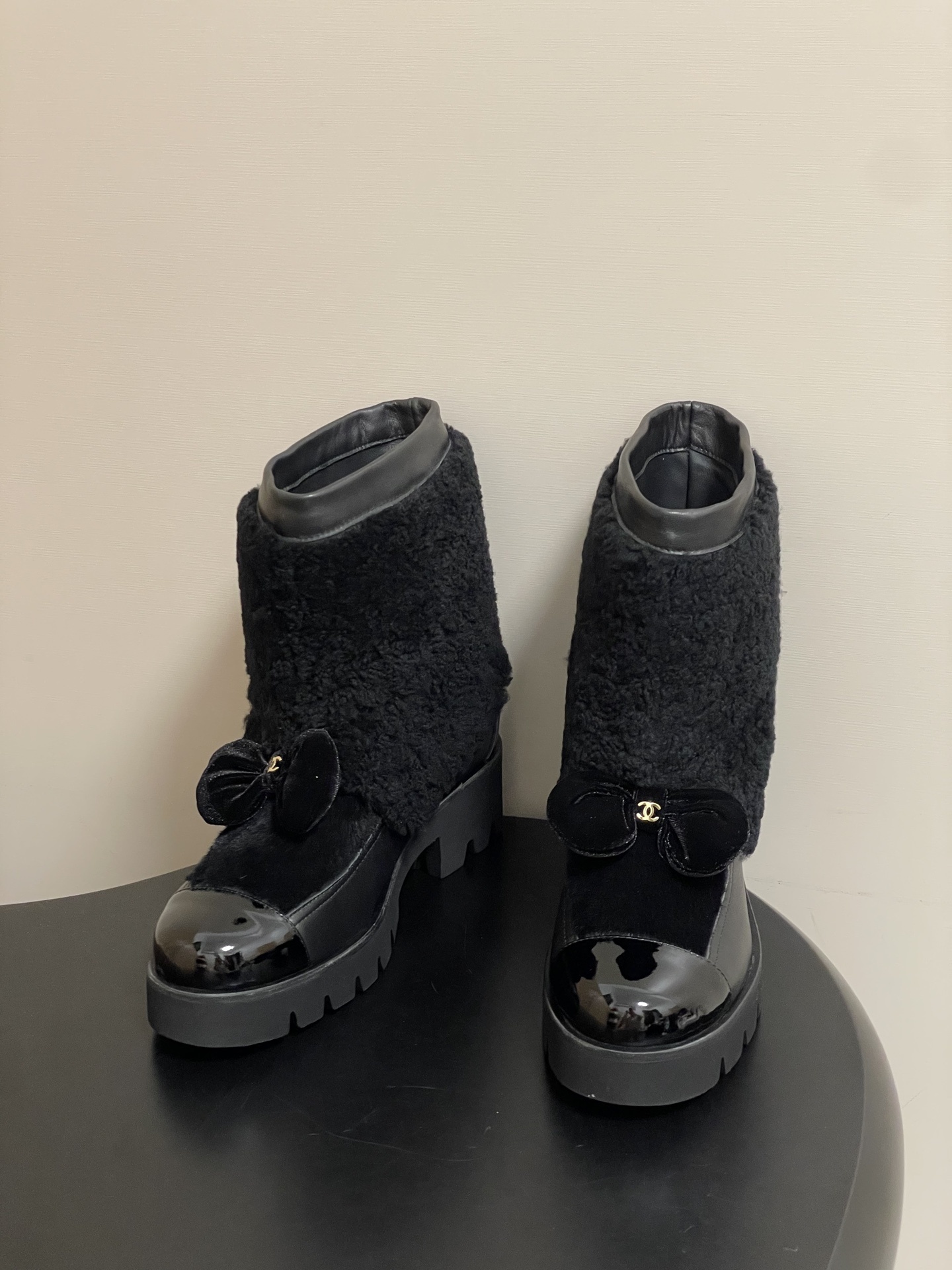 Pair of black luxury ankle boots with faux fur shearling shaft, velvet bow, and chunky lug soles - Hình 2
