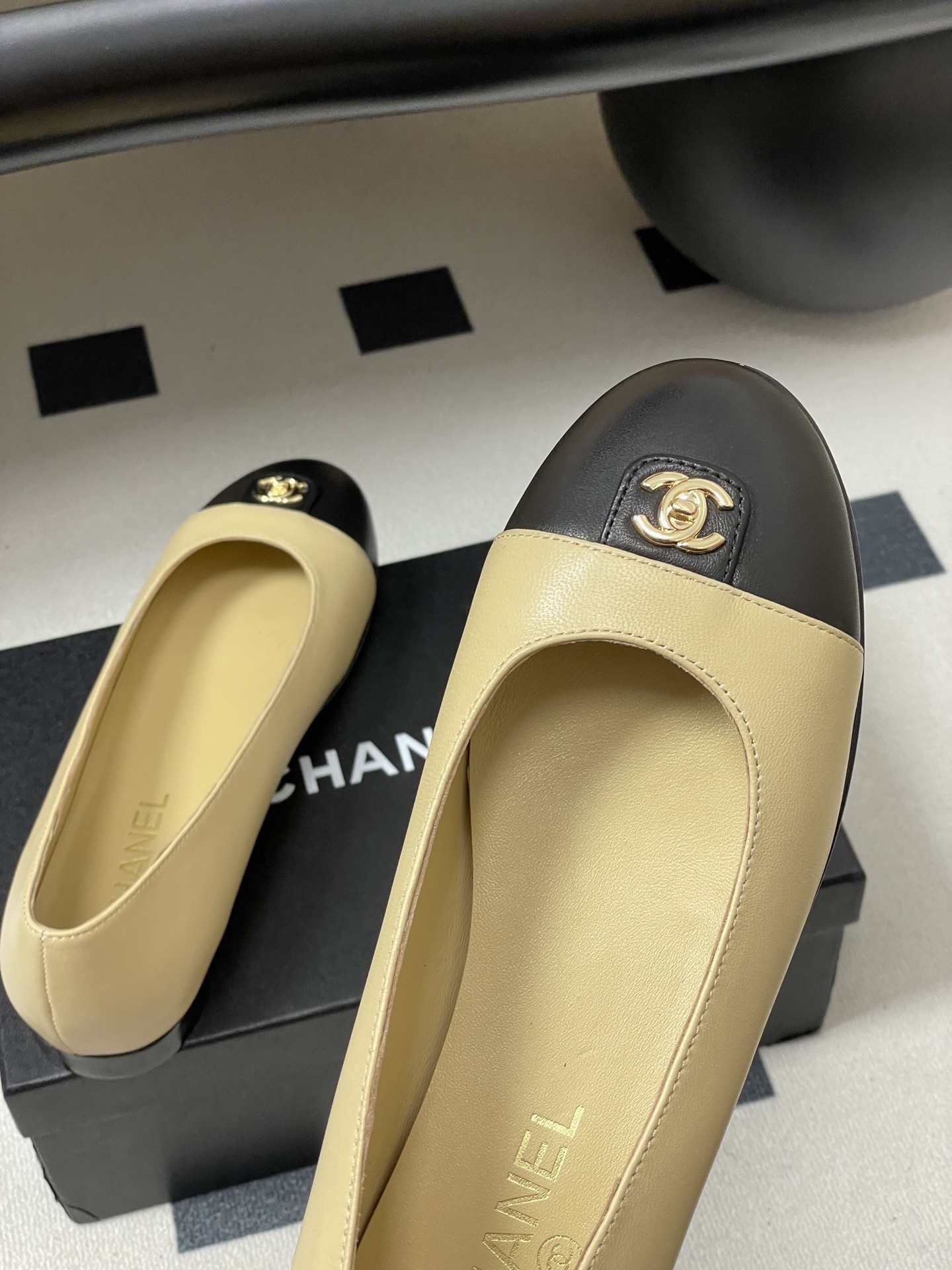 A pair of Chanel two-tone beige and black leather ballet flats featuring a gold CC logo on the toe cap. - Hình 9