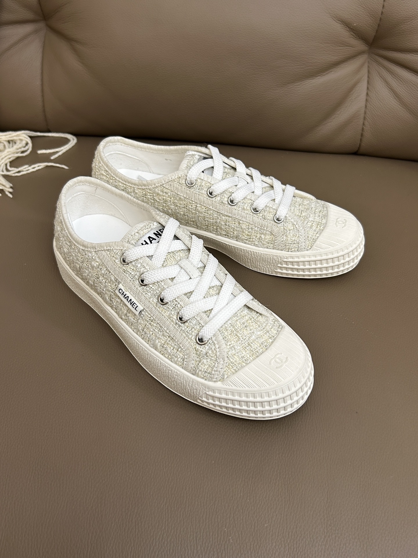 A pair of Chanel white tweed platform sneakers with white laces and CC logo on the rubber toe cap - Hình 6