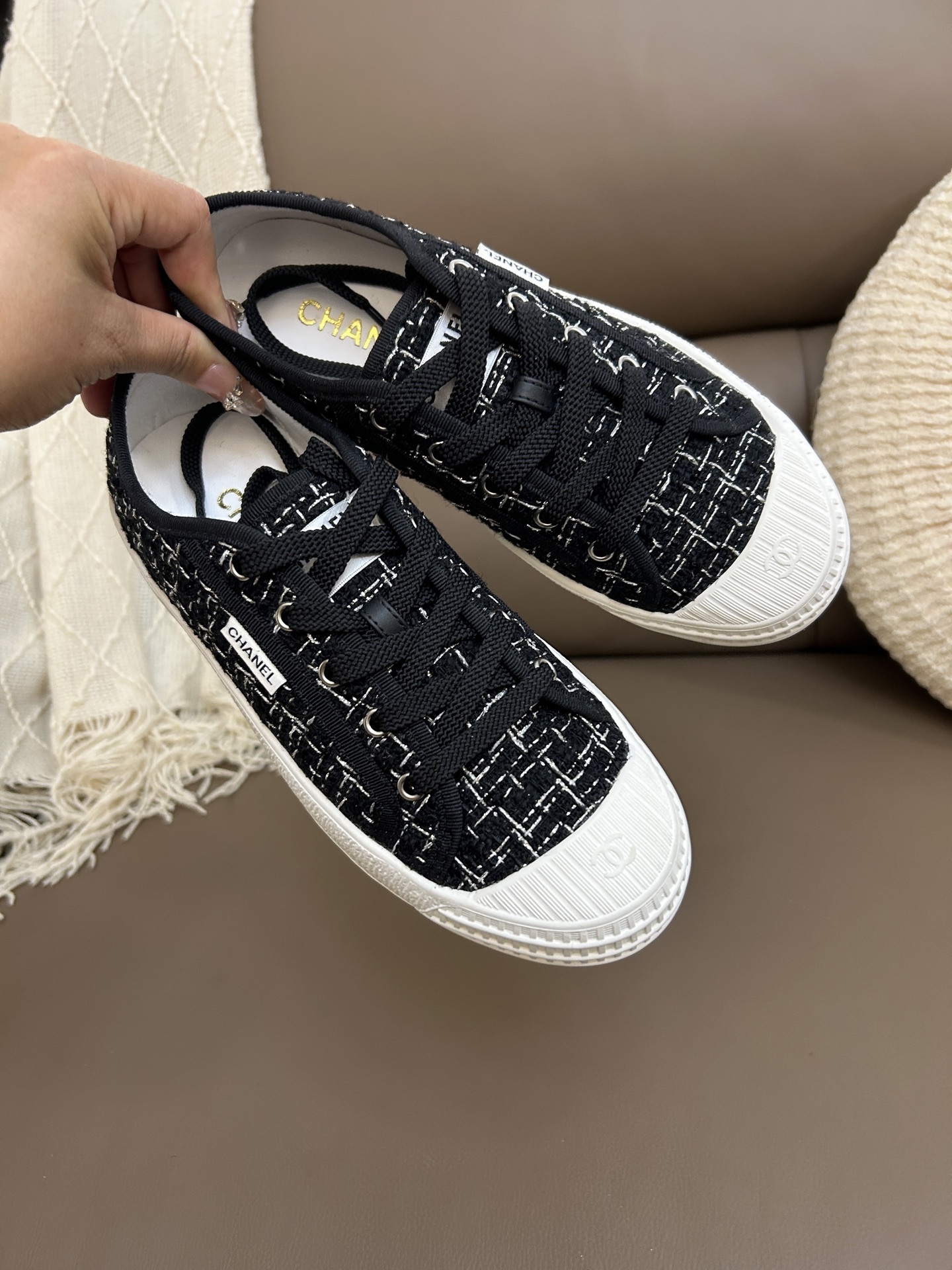 Top view of a pair of Chanel black and white tweed low-top sneakers with white rubber toe caps and CC logo. - Hình 5