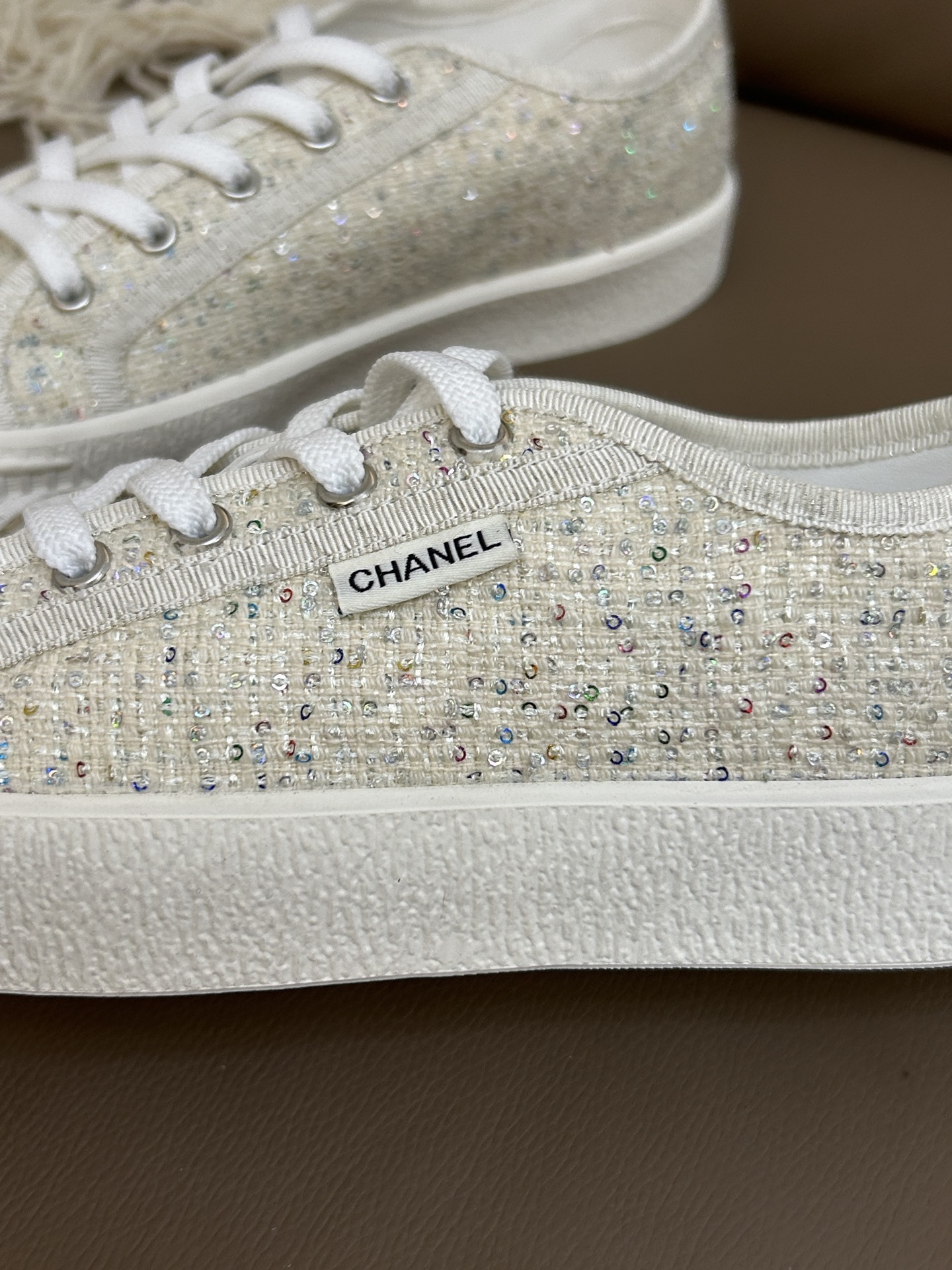 Pair of Chanel beige tweed sneakers with sparkling sequins and platform soles on a brown leather background - Hình 7