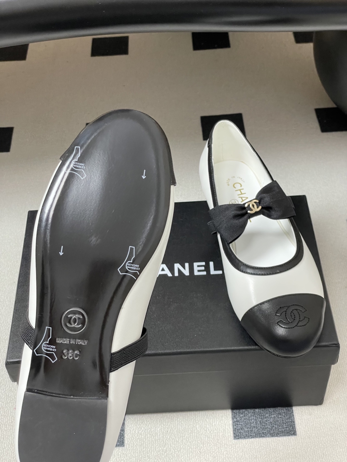 Luxury Chanel white and black leather Mary Jane flats featuring a black bow with gold logo and embroidered cap toe. - Hình 8