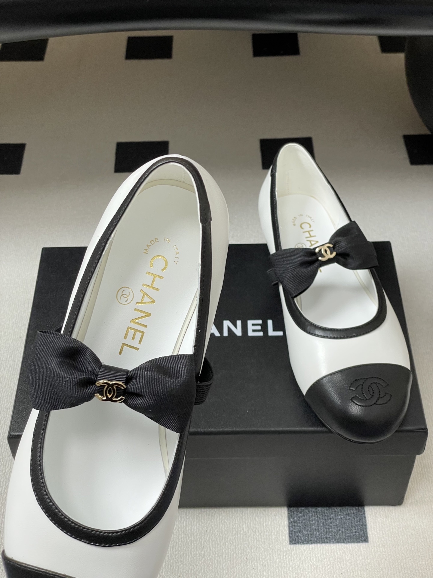 Luxury Chanel white and black leather Mary Jane flats featuring a black bow with gold logo and embroidered cap toe. - Hình 7