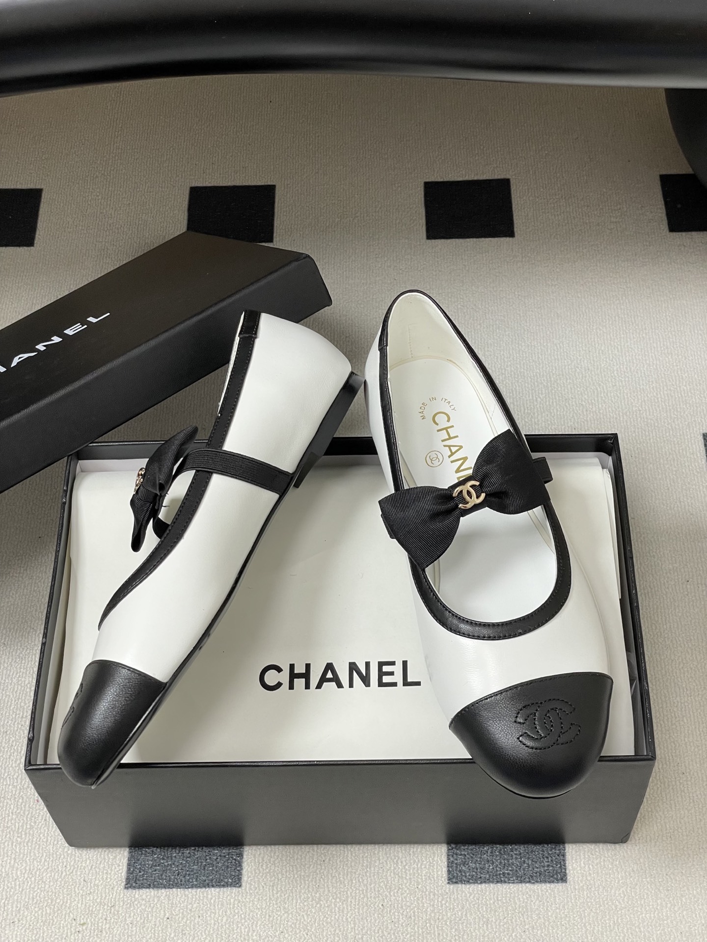 Luxury Chanel white and black leather Mary Jane flats featuring a black bow with gold logo and embroidered cap toe. - Hình 6