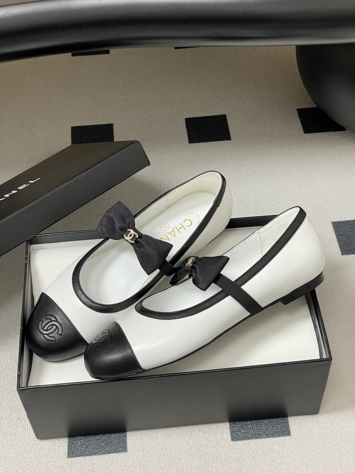 Luxury Chanel white and black leather Mary Jane flats featuring a black bow with gold logo and embroidered cap toe. - Hình 4
