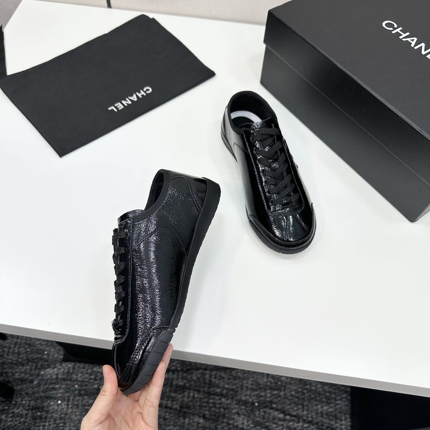 Luxury Chanel low-top sneakers in shiny black patent leather featuring an embossed CC logo on the side - Hình 10