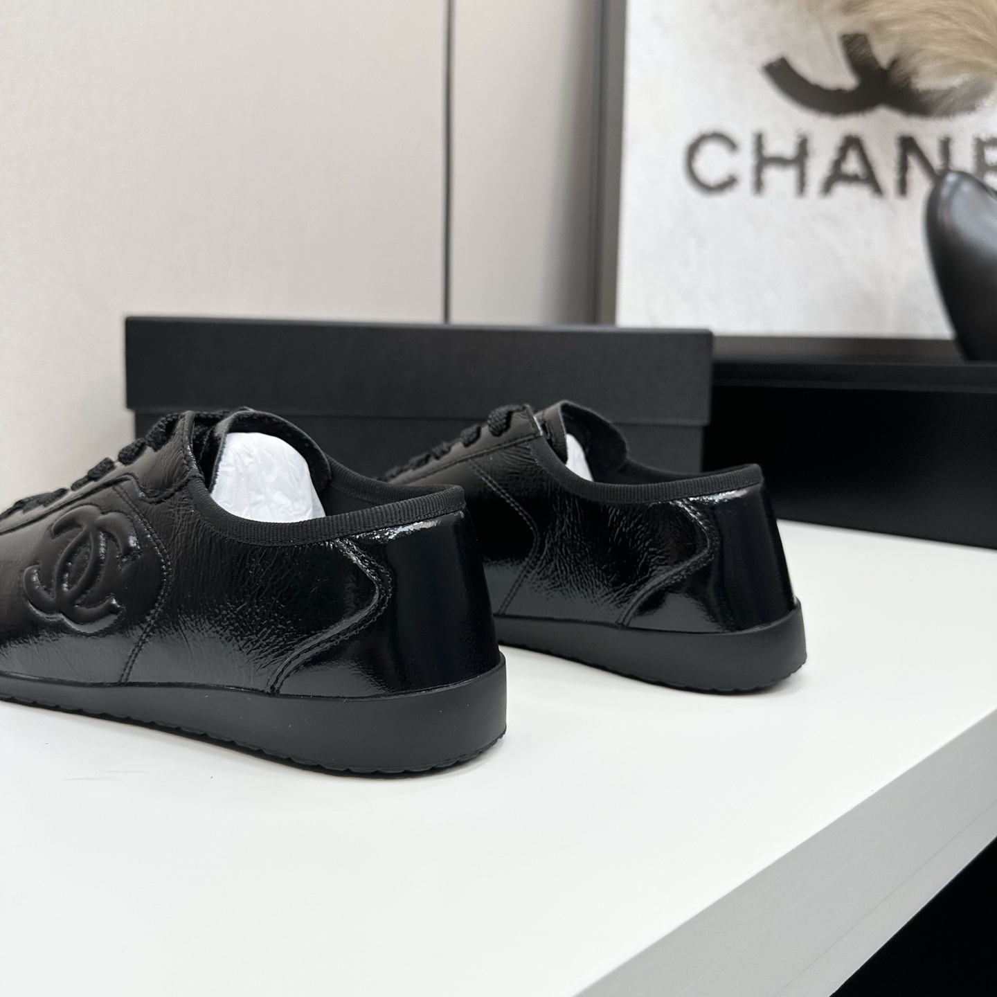 Luxury Chanel low-top sneakers in shiny black patent leather featuring an embossed CC logo on the side - Hình 9