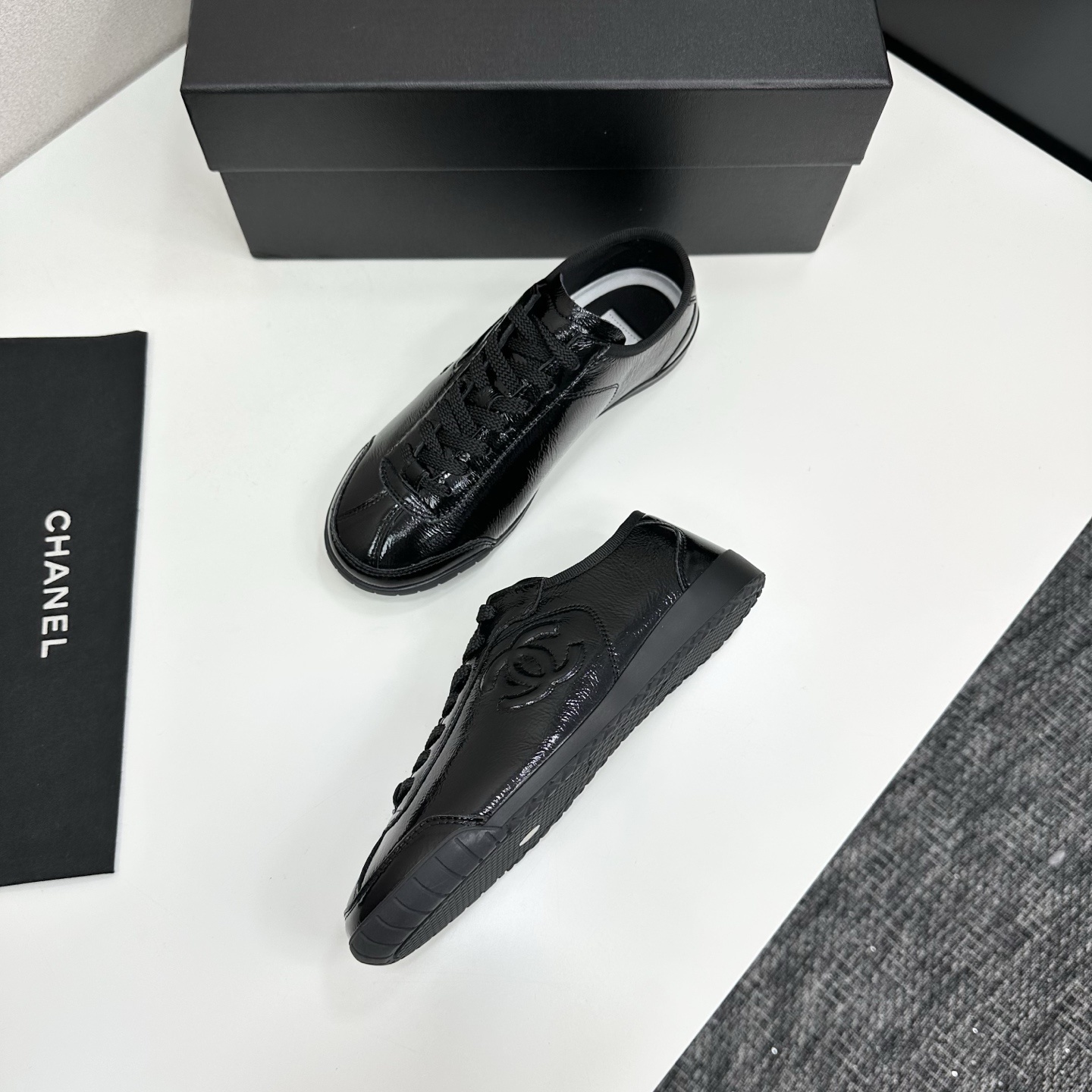 Luxury Chanel low-top sneakers in shiny black patent leather featuring an embossed CC logo on the side - Hình 7