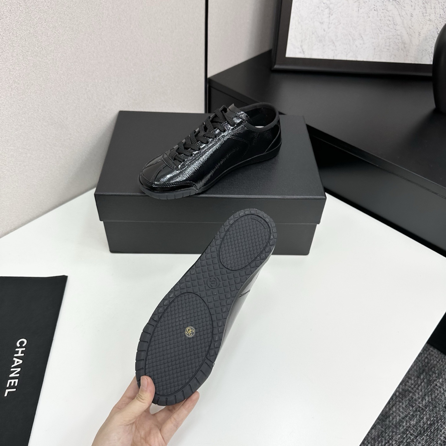 Luxury Chanel low-top sneakers in shiny black patent leather featuring an embossed CC logo on the side - Hình 5