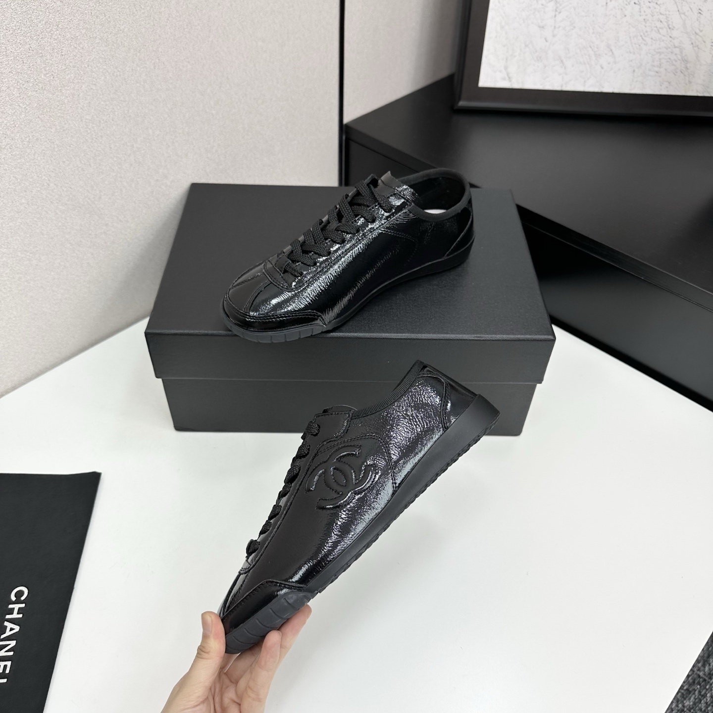 Luxury Chanel low-top sneakers in shiny black patent leather featuring an embossed CC logo on the side - Hình 4