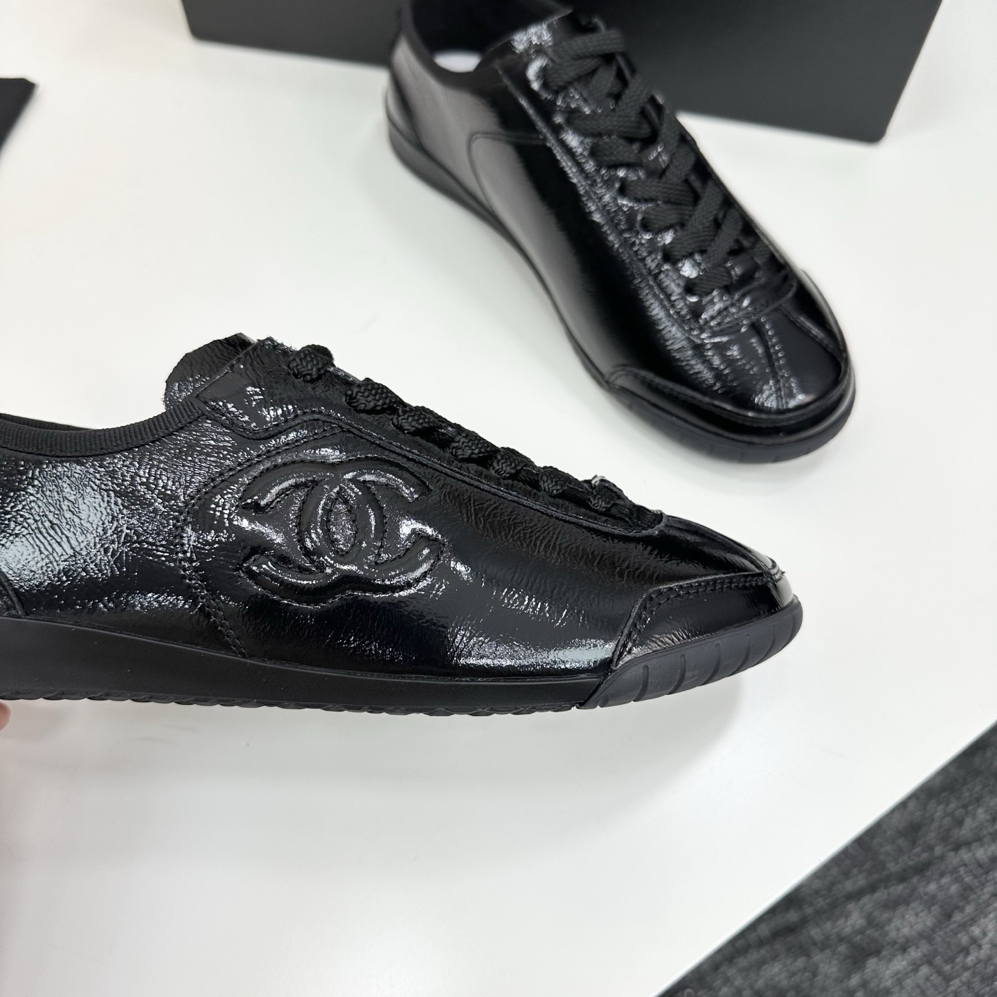 Luxury Chanel low-top sneakers in shiny black patent leather featuring an embossed CC logo on the side - Hình 2