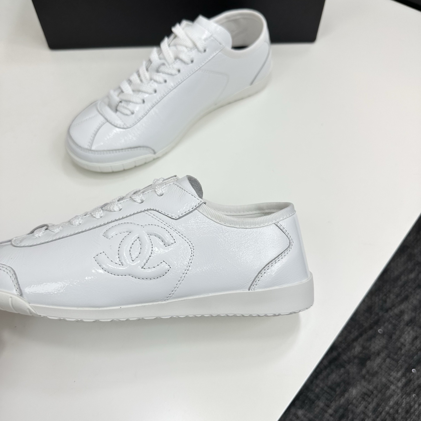 Pair of Chanel white leather low-top sneakers featuring the interlocking CC logo on the side. - Hình 7