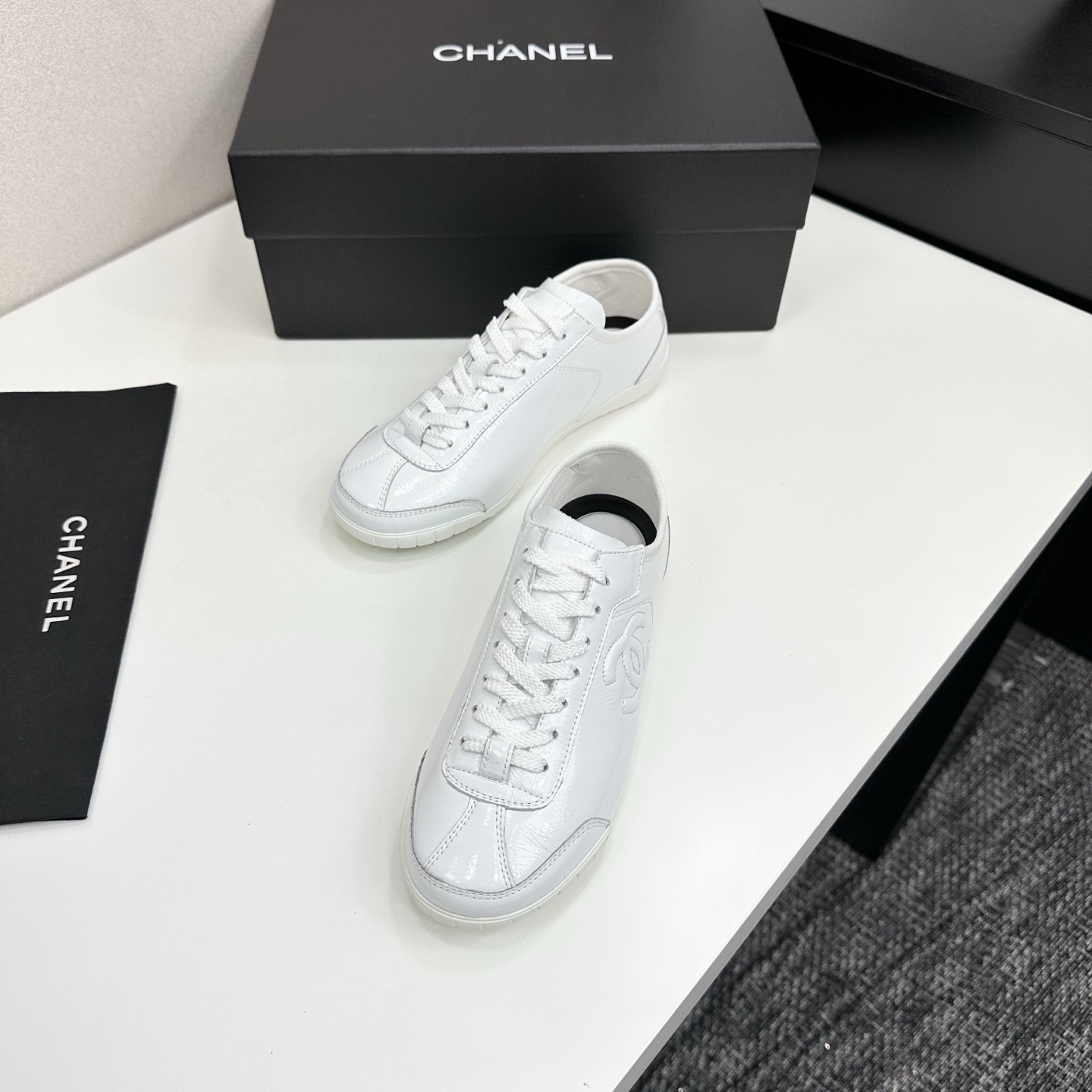 Pair of Chanel white leather low-top sneakers featuring the interlocking CC logo on the side. - Hình 5