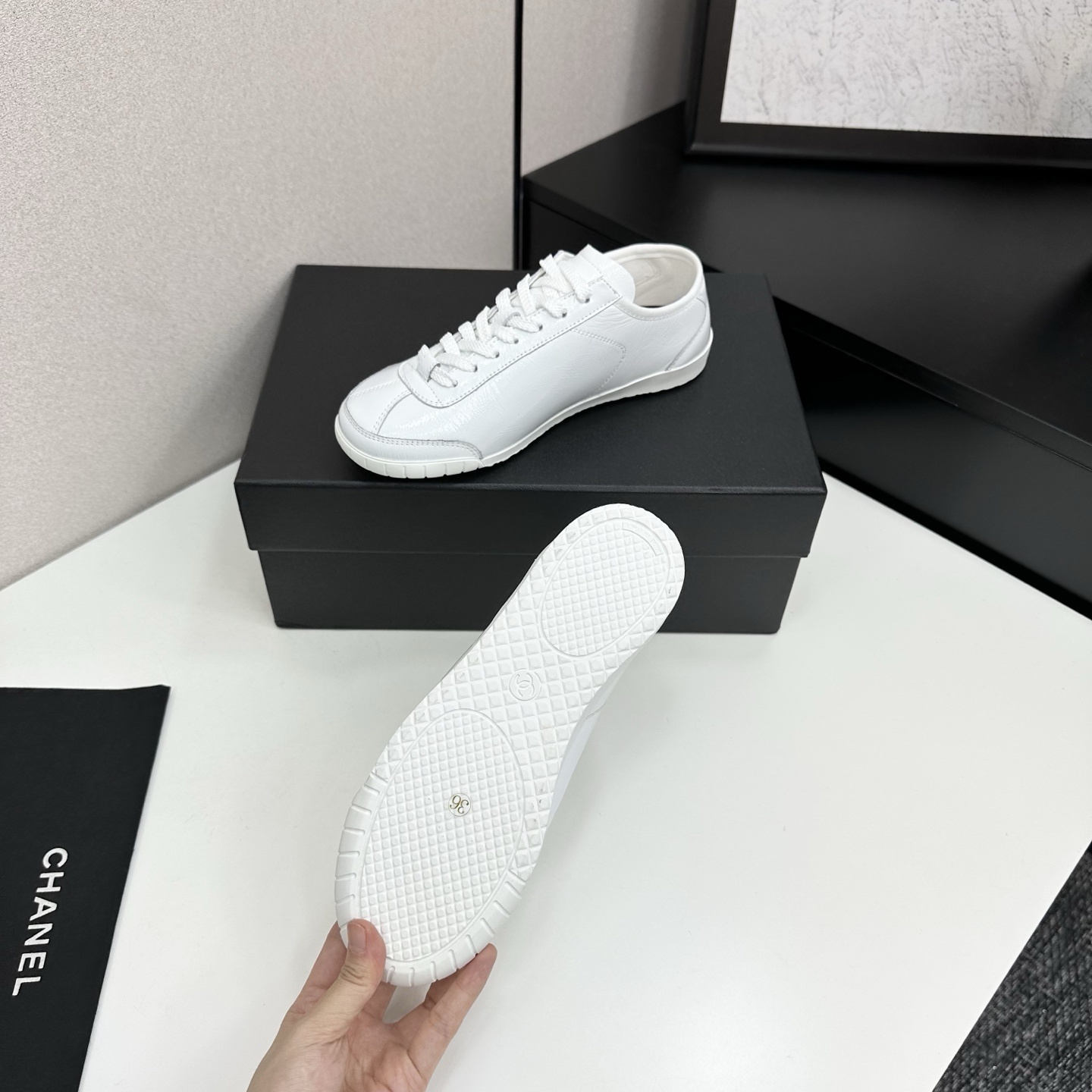 Pair of Chanel white leather low-top sneakers featuring the interlocking CC logo on the side. - Hình 4