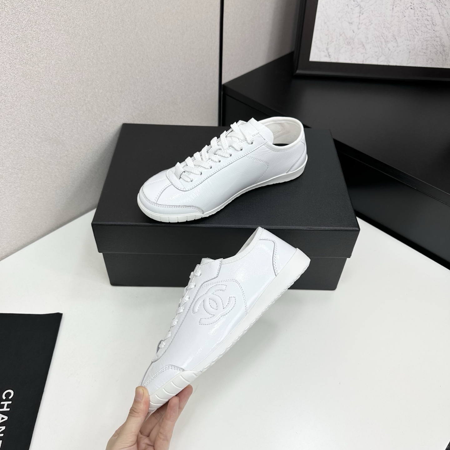 Pair of Chanel white leather low-top sneakers featuring the interlocking CC logo on the side. - Hình 3
