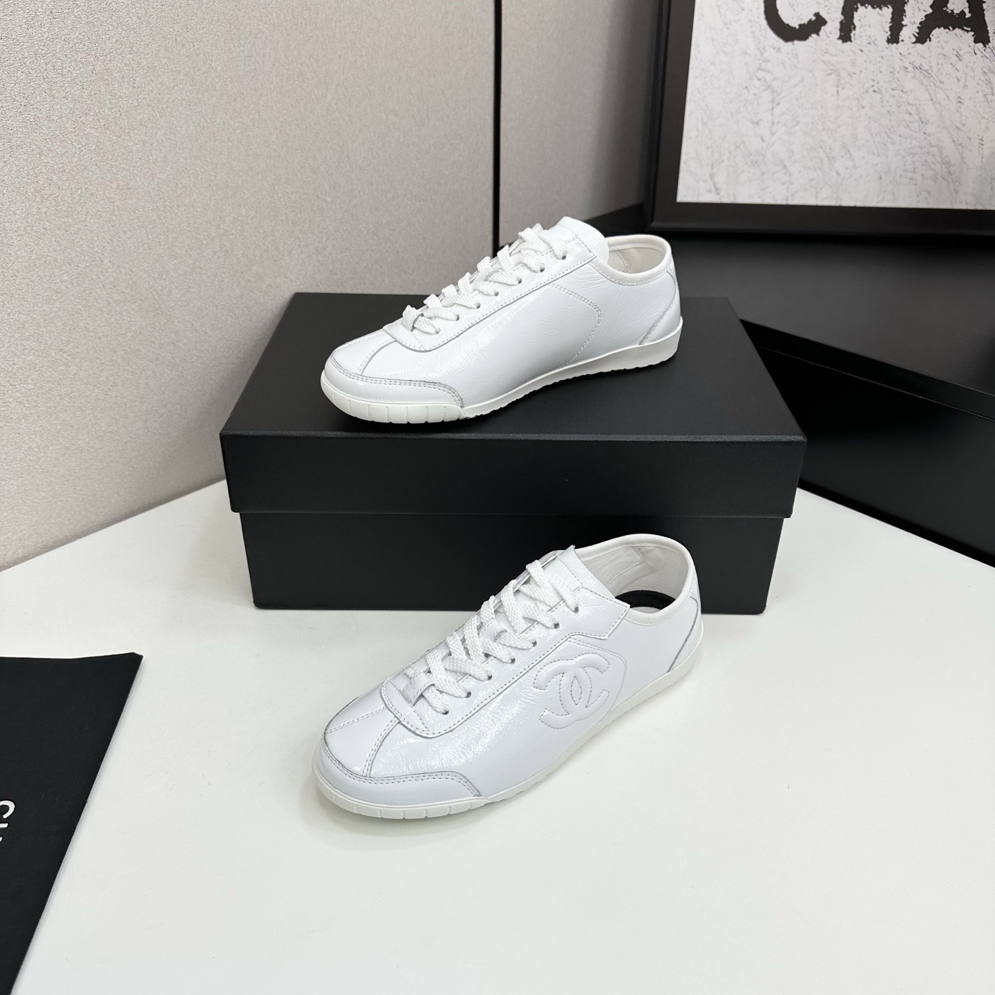 Pair of Chanel white leather low-top sneakers featuring the interlocking CC logo on the side. - Hình 2