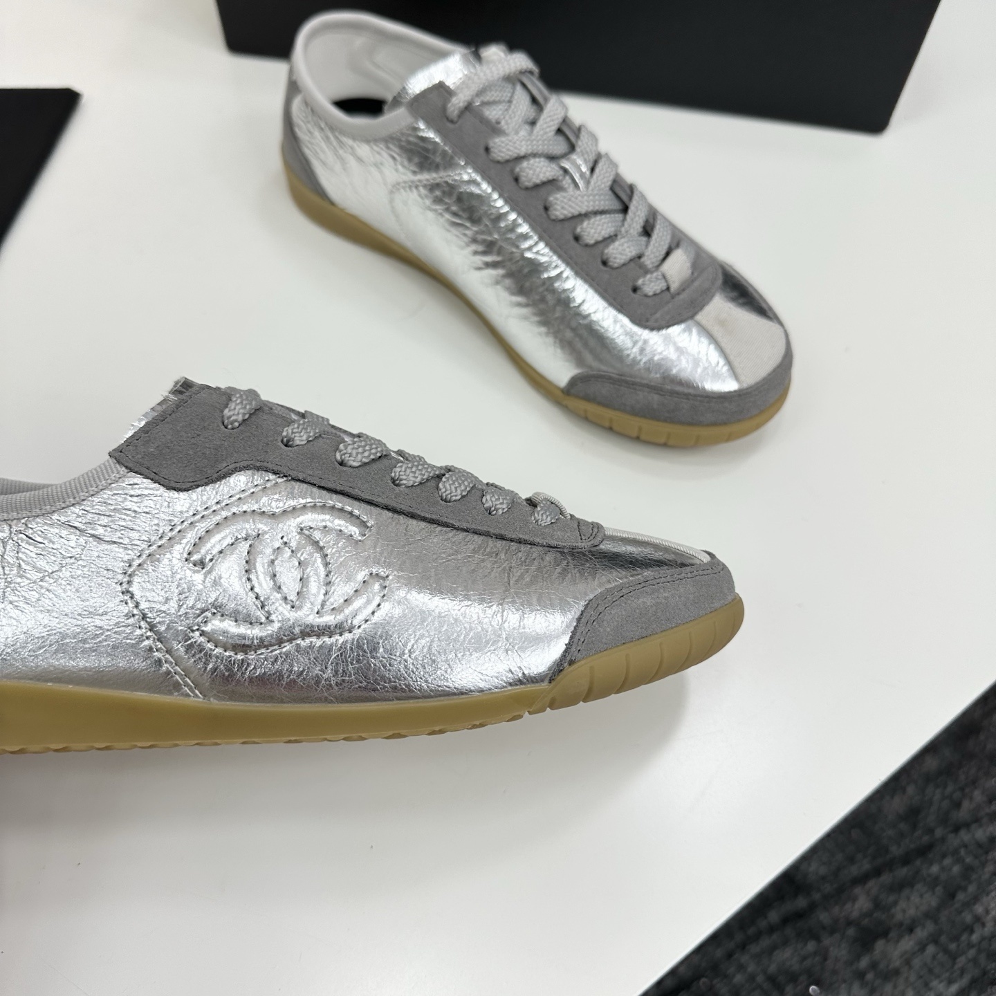 Luxury Chanel low-top sneakers in metallic silver leather and grey suede with a gum sole and CC logo. - Hình 9