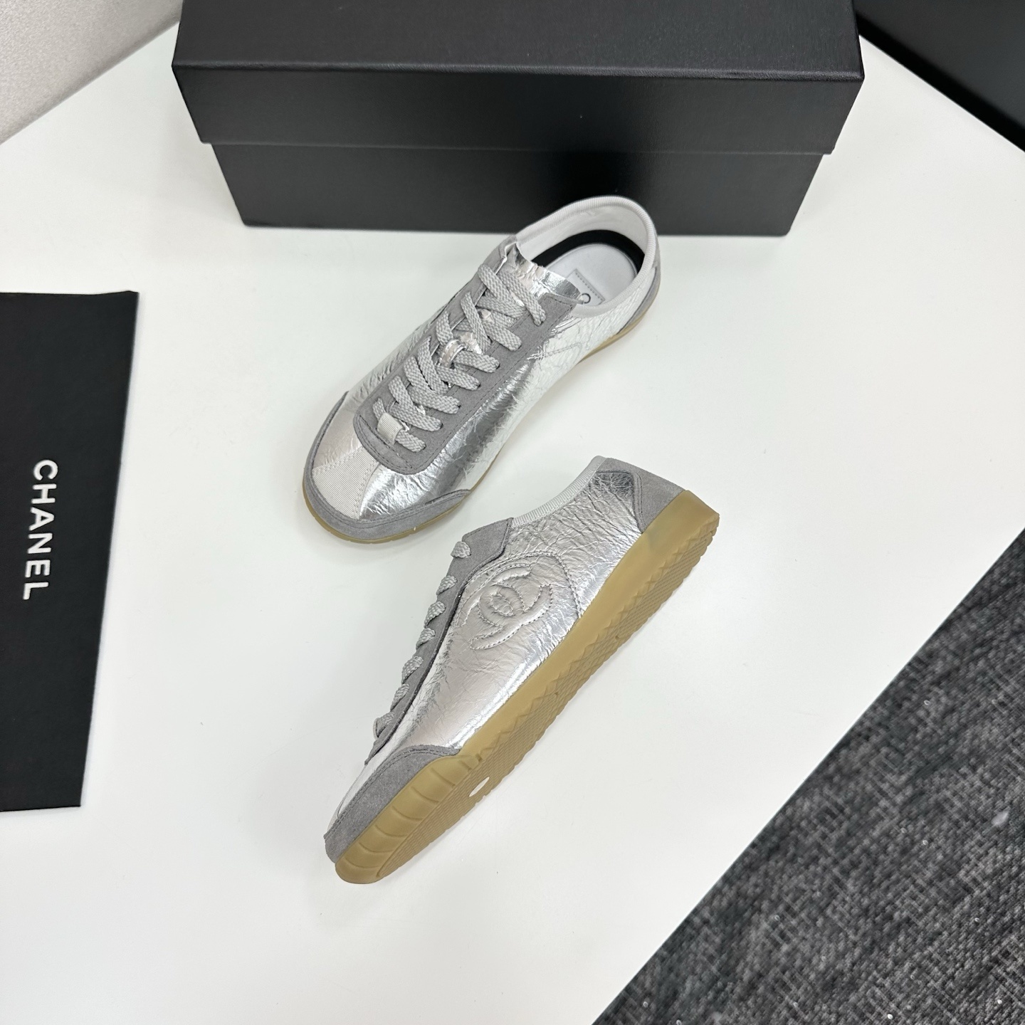 Luxury Chanel low-top sneakers in metallic silver leather and grey suede with a gum sole and CC logo. - Hình 6