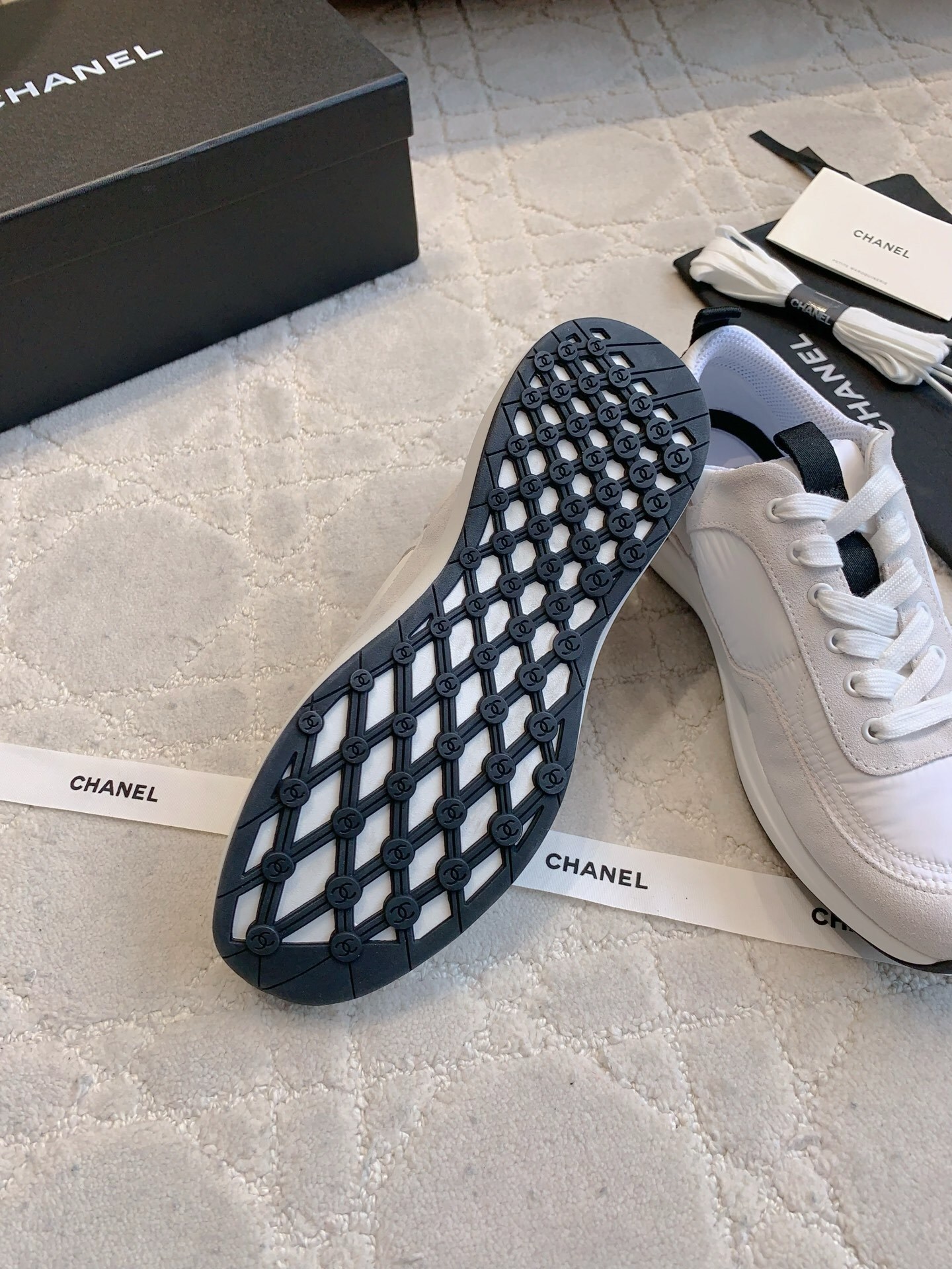 Authentic Chanel white and grey low-top sneakers with black CC logo, shown with original box, dust bag, and accessories. - Hình 9