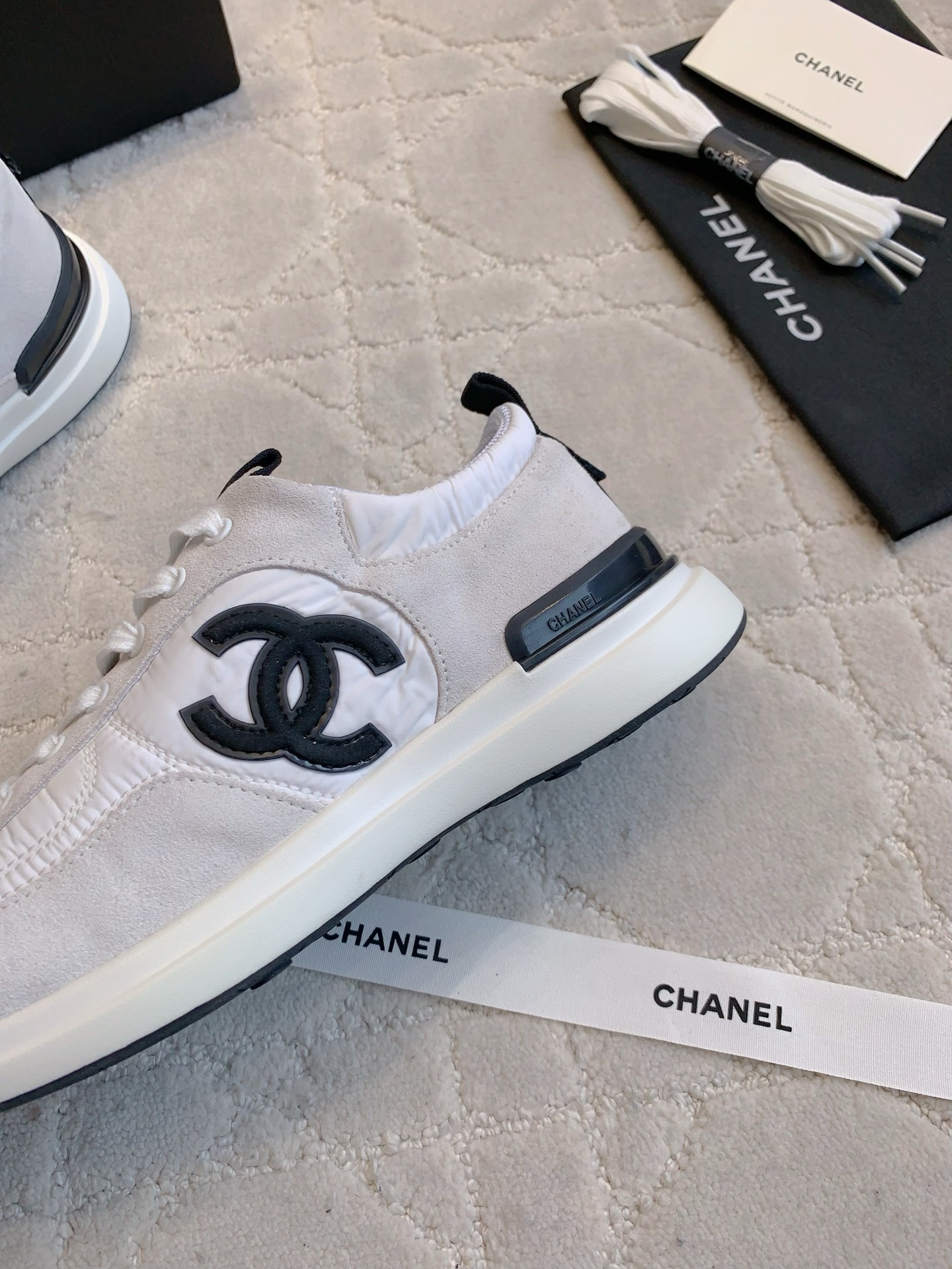 Authentic Chanel white and grey low-top sneakers with black CC logo, shown with original box, dust bag, and accessories. - Hình 7
