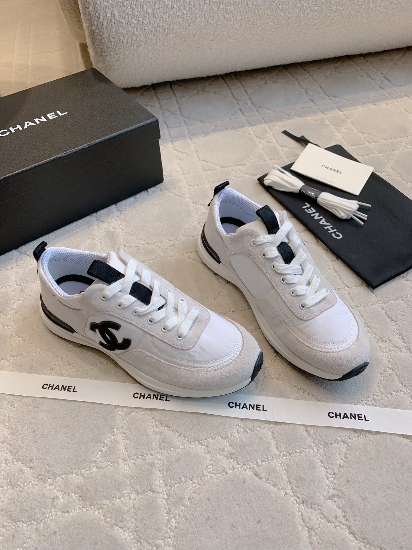 Authentic Chanel white and grey low-top sneakers with black CC logo, shown with original box, dust bag, and accessories. - Hình 3