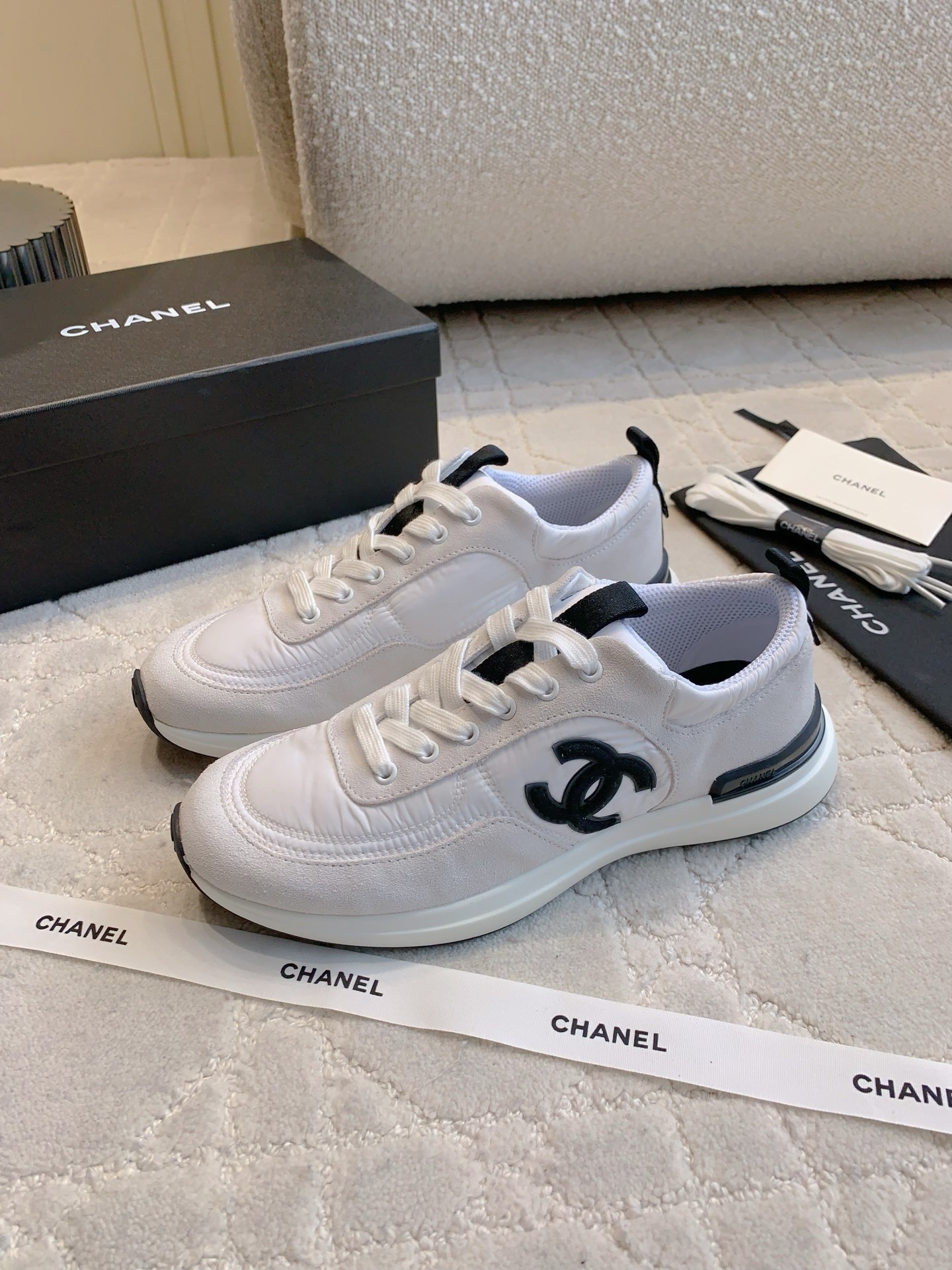 Authentic Chanel white and grey low-top sneakers with black CC logo, shown with original box, dust bag, and accessories. - Hình 2