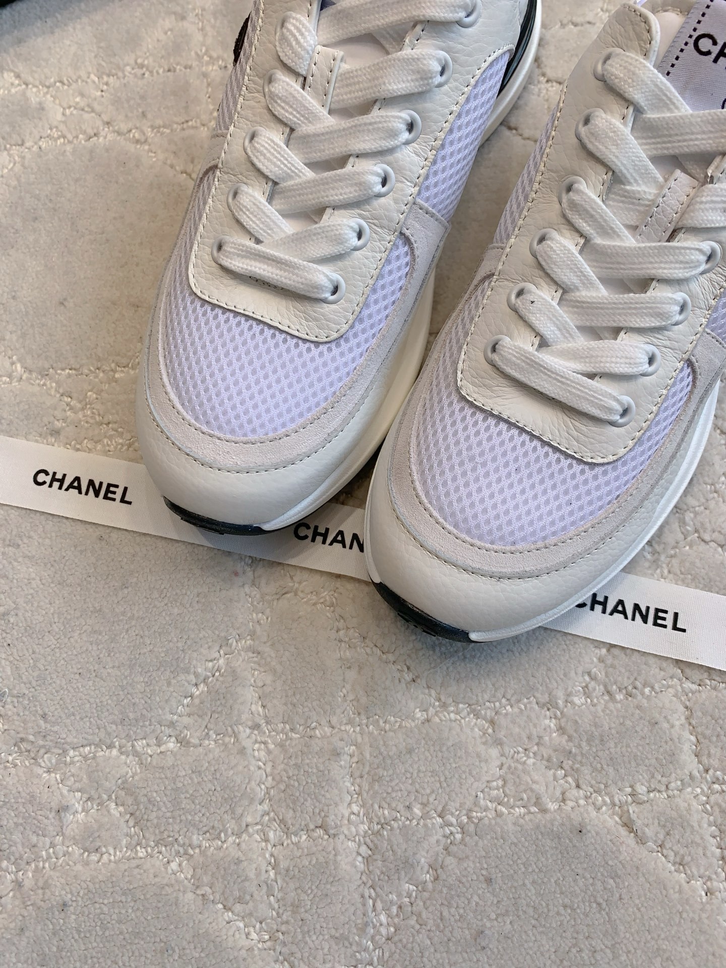 Pair of Chanel white leather and mesh sneakers with black CC logo displayed with original box and accessories. - Hình 5