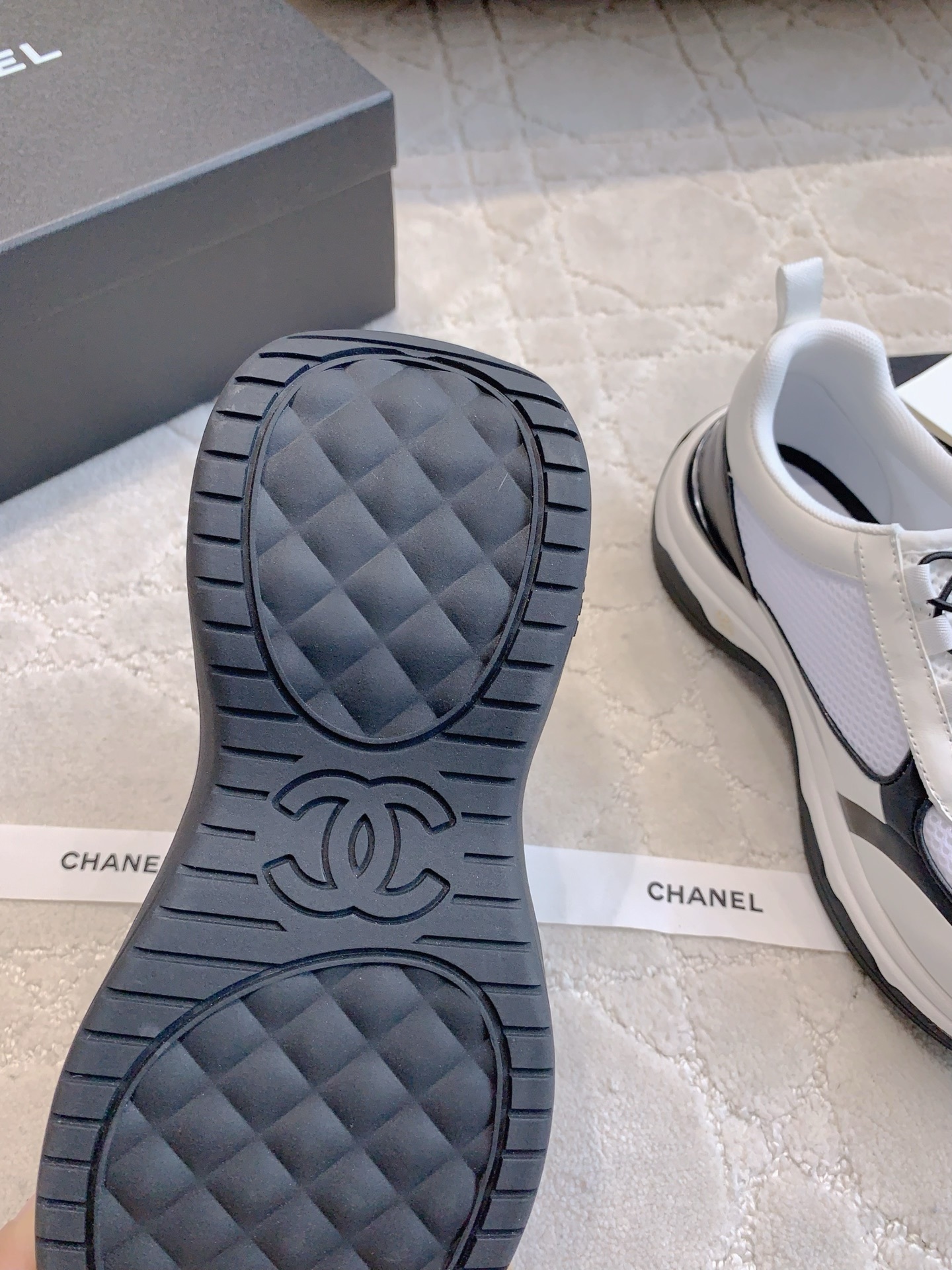 Chanel white and black mesh sneakers with CC logo and chunky sole displayed with original luxury packaging. - Hình 9
