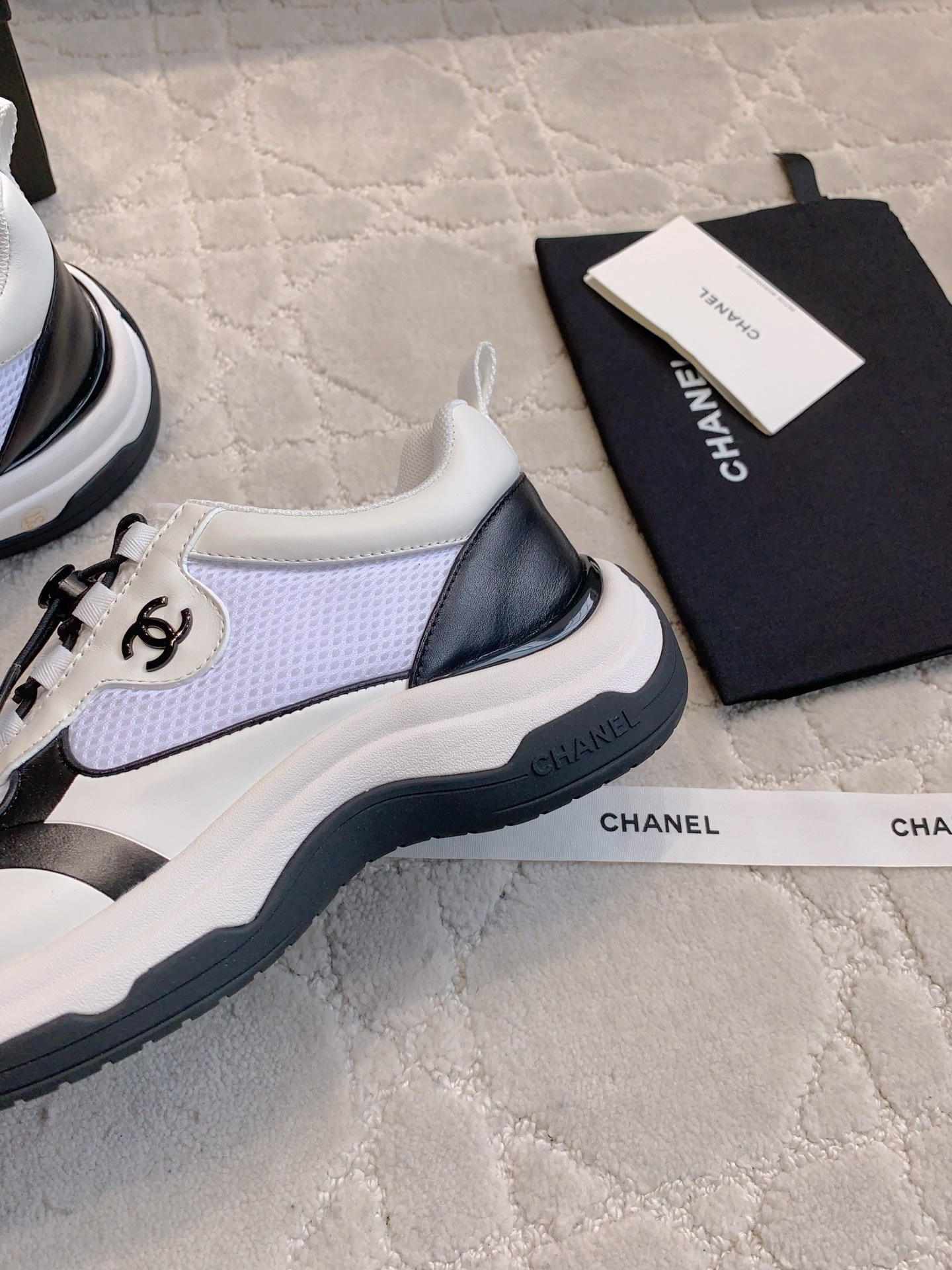Chanel white and black mesh sneakers with CC logo and chunky sole displayed with original luxury packaging. - Hình 7