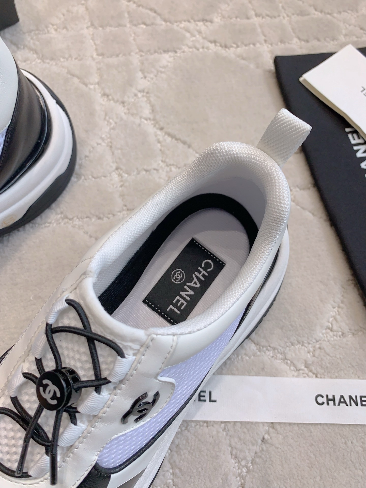 Chanel white and black mesh sneakers with CC logo and chunky sole displayed with original luxury packaging. - Hình 6