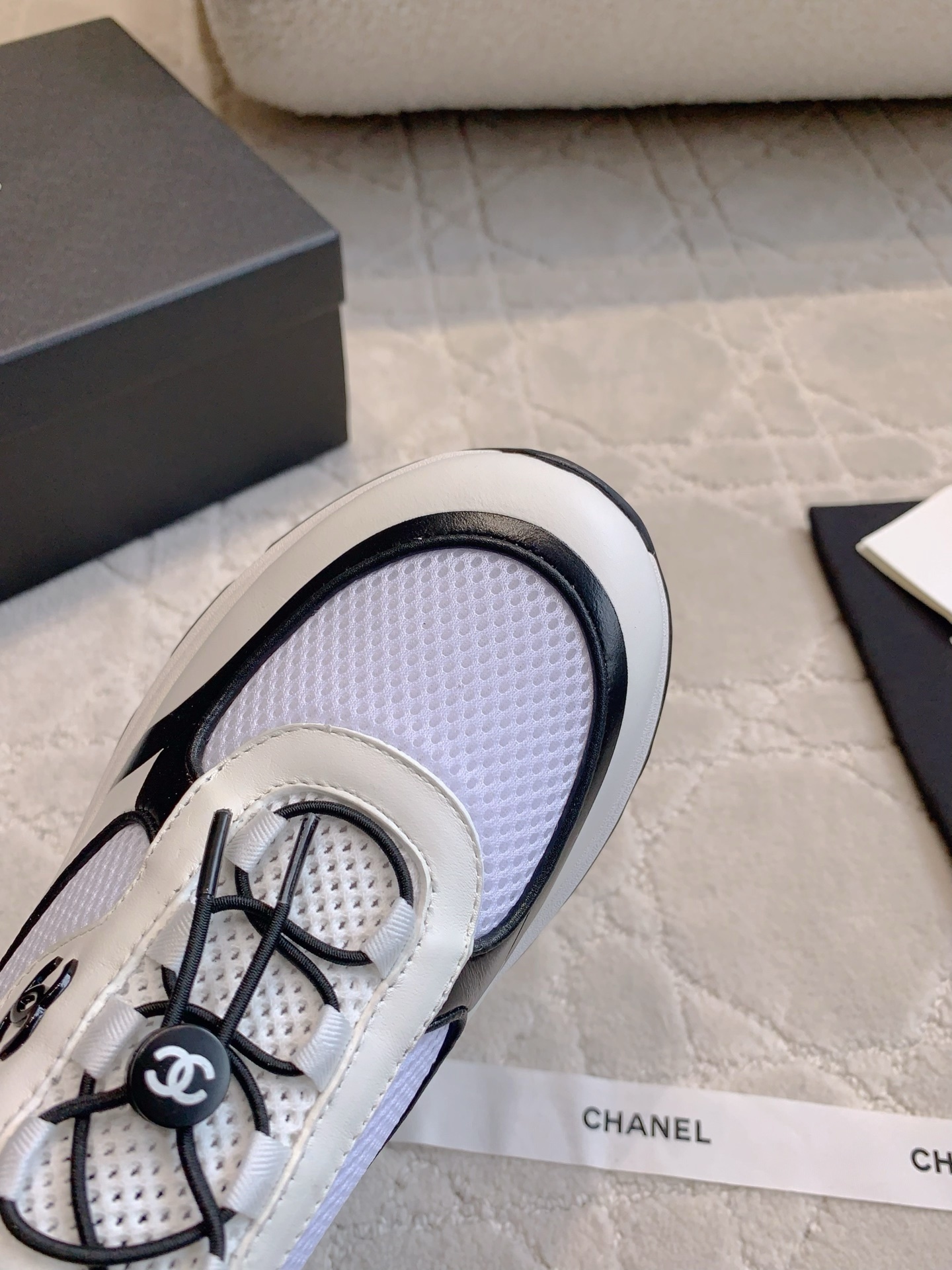 Chanel white and black mesh sneakers with CC logo and chunky sole displayed with original luxury packaging. - Hình 4