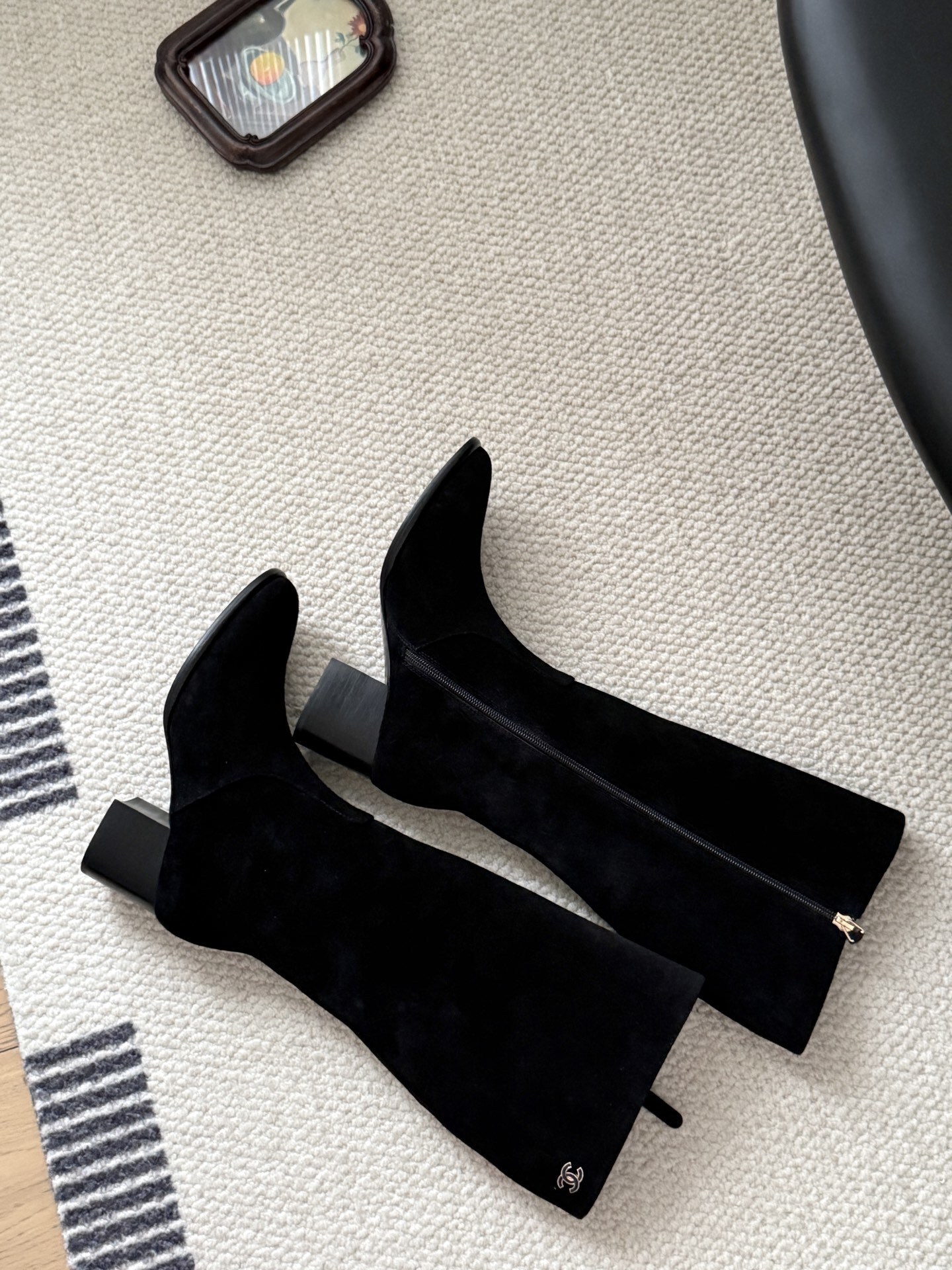 Pair of elegant black suede knee-high boots featuring a gold logo and a comfortable block heel. - Hình 9