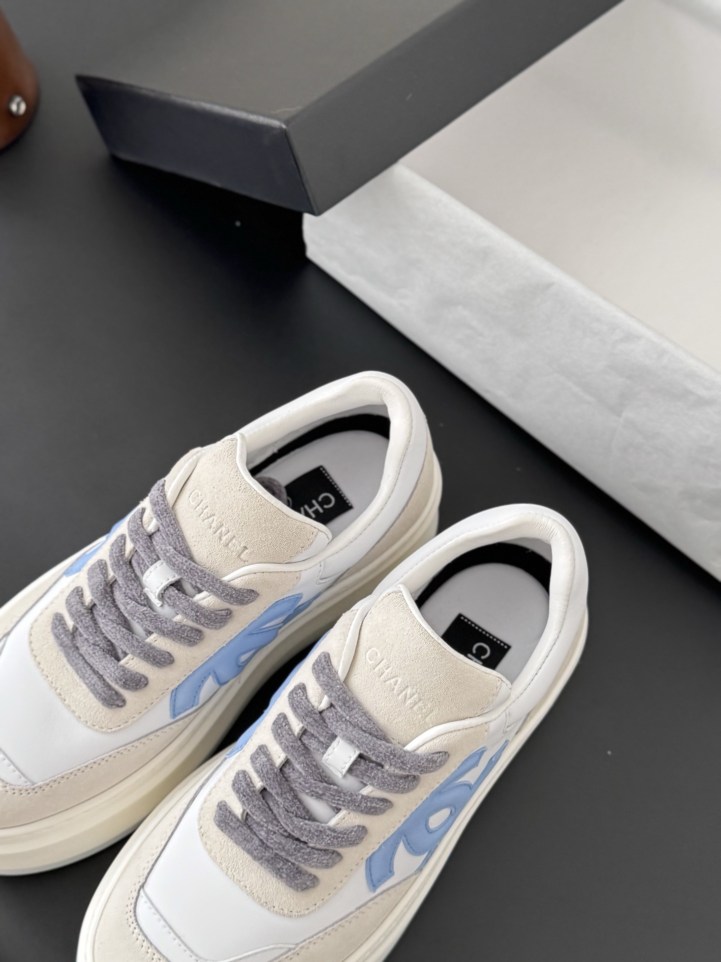 Pair of Chanel white and light blue platform sneakers with a black designer box - Hình 5