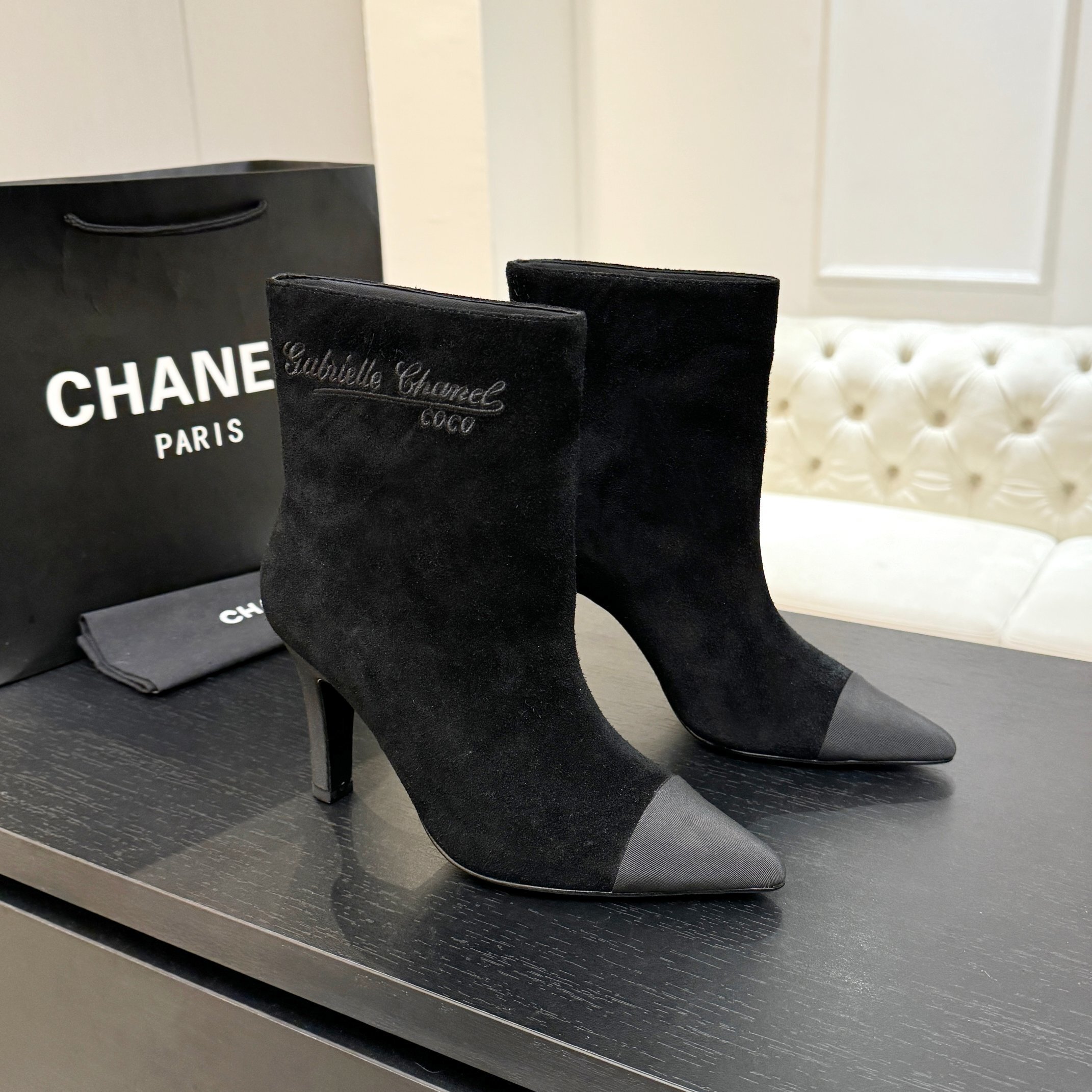 Pair of luxury Chanel Gabrielle black suede ankle boots with pointed grey cap-toe and COCO embroidery detail. - Hình 2
