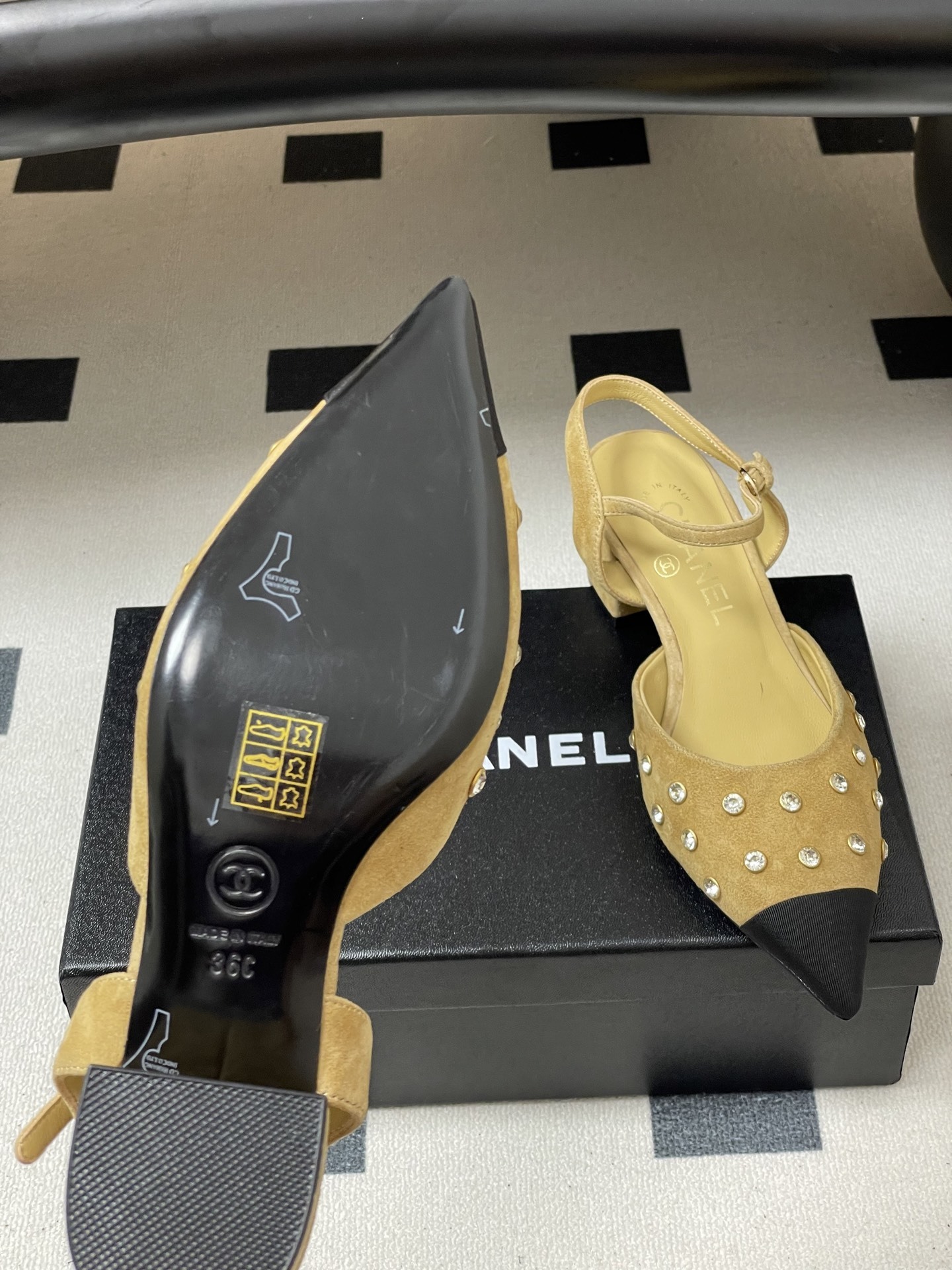 Pair of Chanel beige suede slingback pumps with black cap toes and crystal studs on a black surface - Hình 8